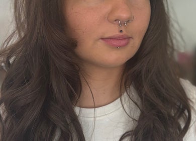 A close-up of styled brown curls and piercings at Kerry Miller Hair, Cove Bay, Scotland, GB.