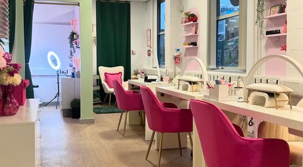Stylish interior of The Beauty Bar Bristol, Stoke Gifford, England, GB with pink chairs and a nail station.