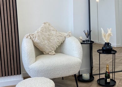 Relaxing chair setup at Bare Beauty, Bournemouth, England, GB with chic decor and plush pillows.
