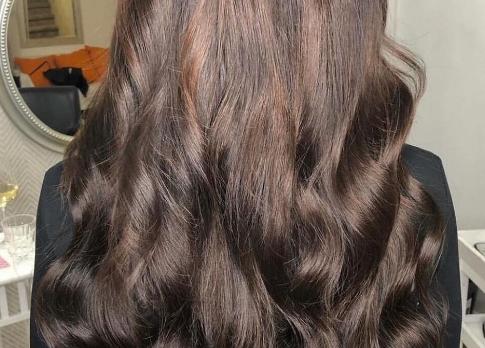 Cheveux ondulés et brillants réalisés à Vivi Extension, Mirabel, Québec, CA, dans un cadre élégant.