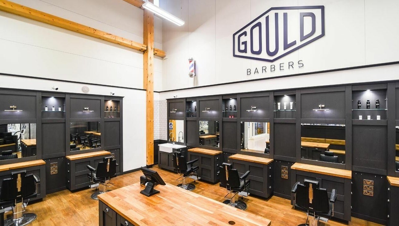 Modern interior of Gould Barbers Huntingdon in Huntingdon, England, GB, showcasing sleek workstations and elegant decor.