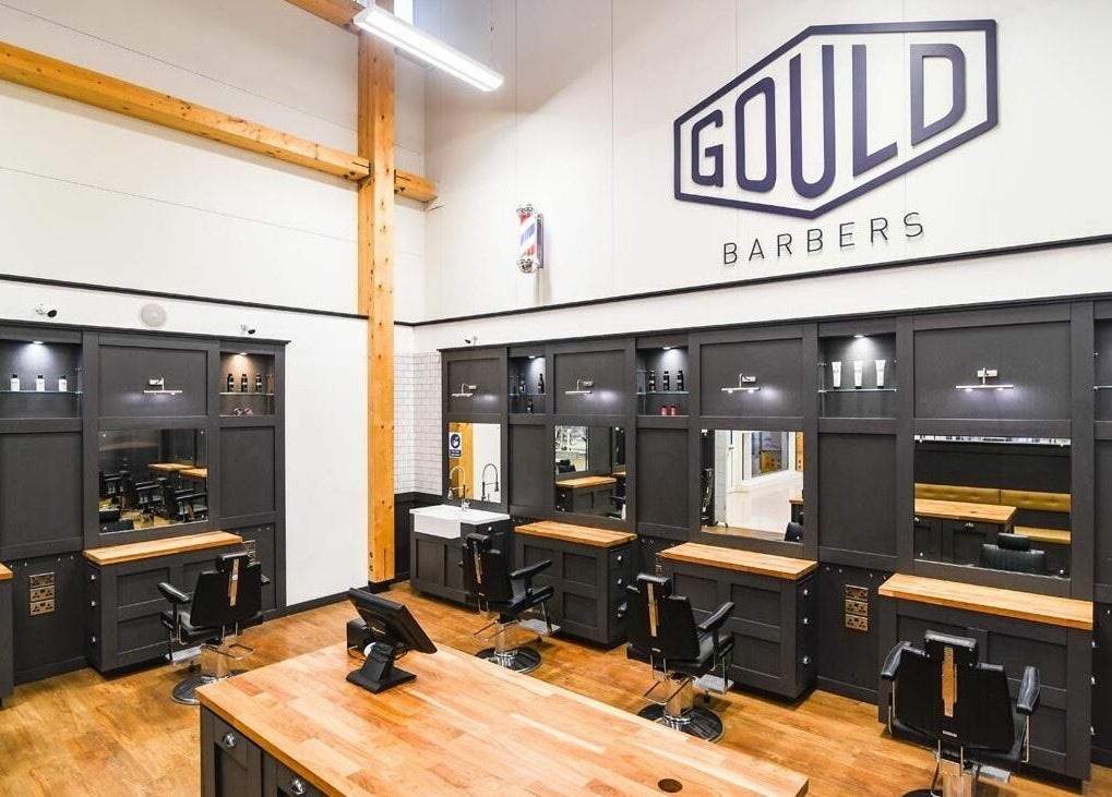 Modern interior of Gould Barbers Huntingdon in Huntingdon, England, GB, showcasing sleek workstations and elegant decor.