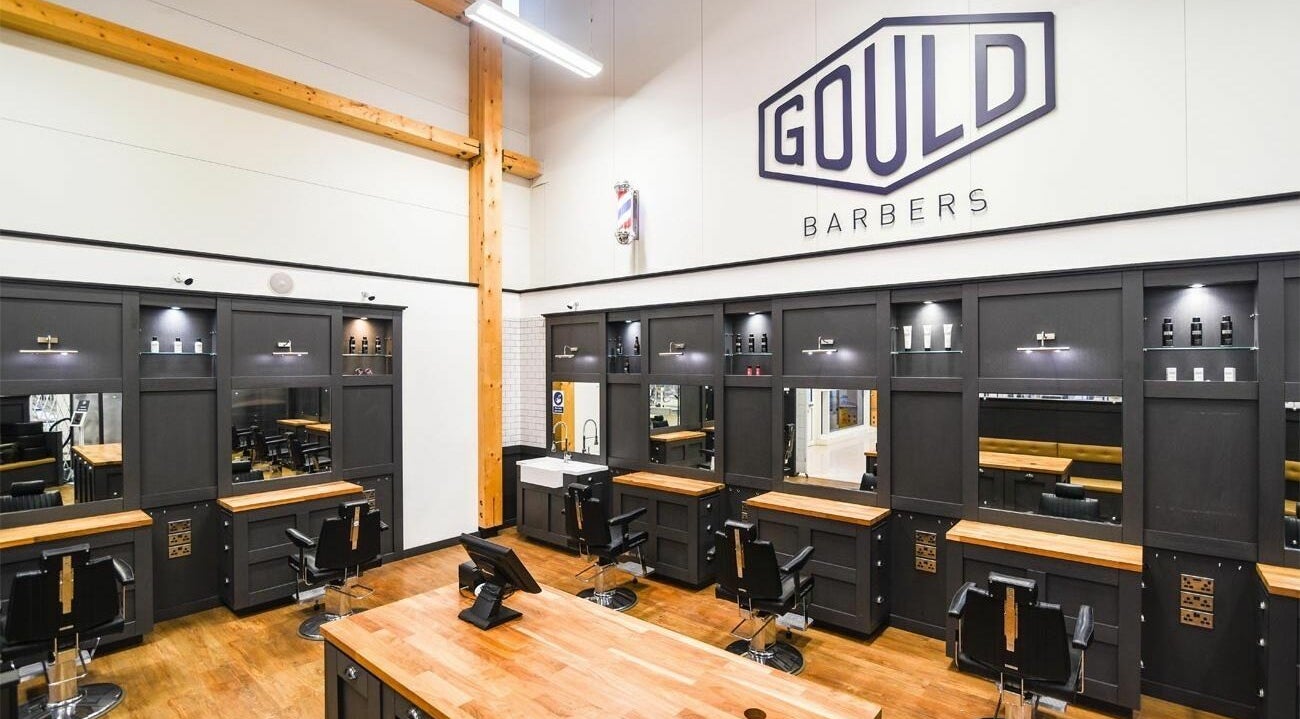 Modern interior of Gould Barbers Huntingdon in Huntingdon, England, GB, showcasing sleek workstations and elegant decor.