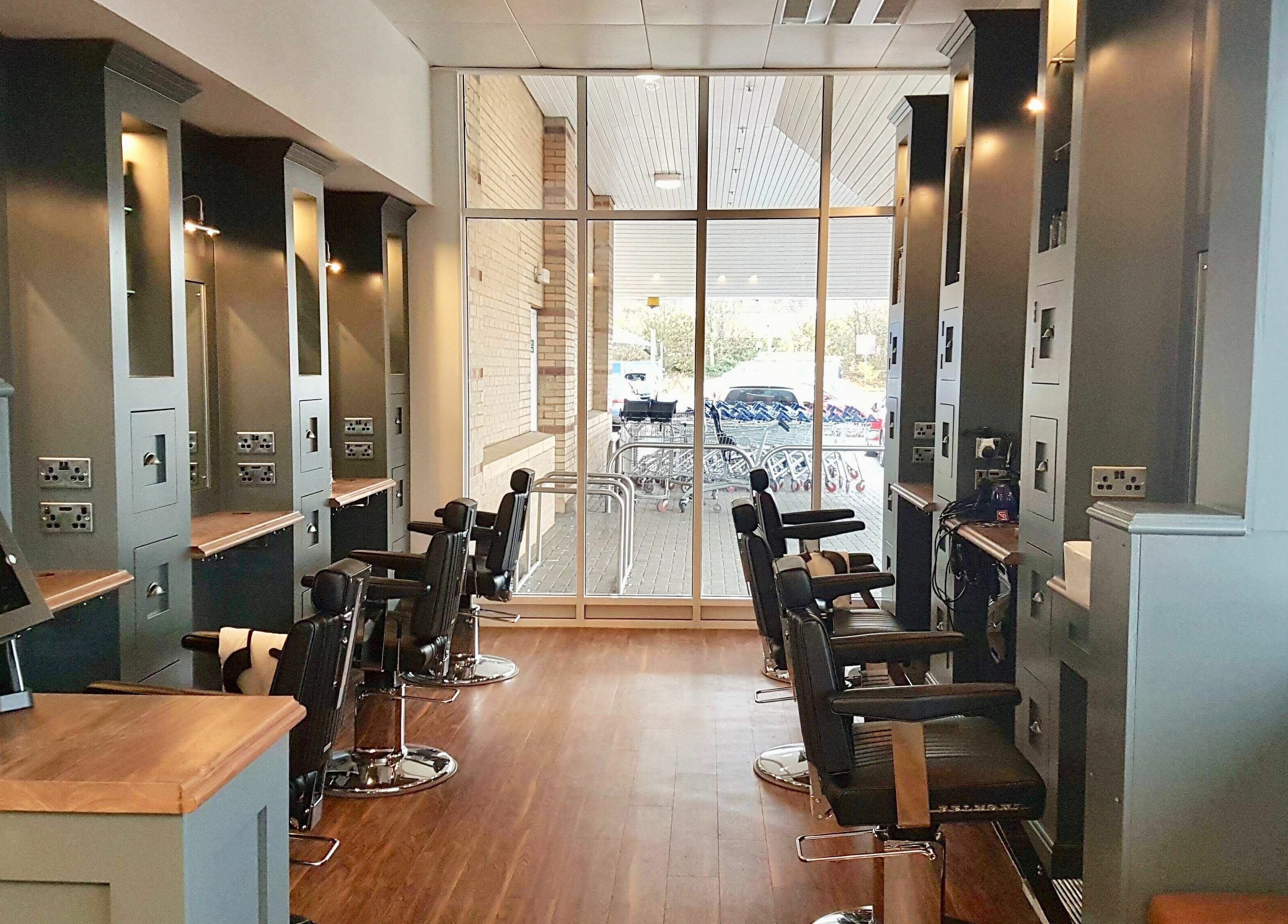 Spacious interior of Gould Barbers Huntingdon, England, GB, showcasing modern barber chairs and sleek decor.