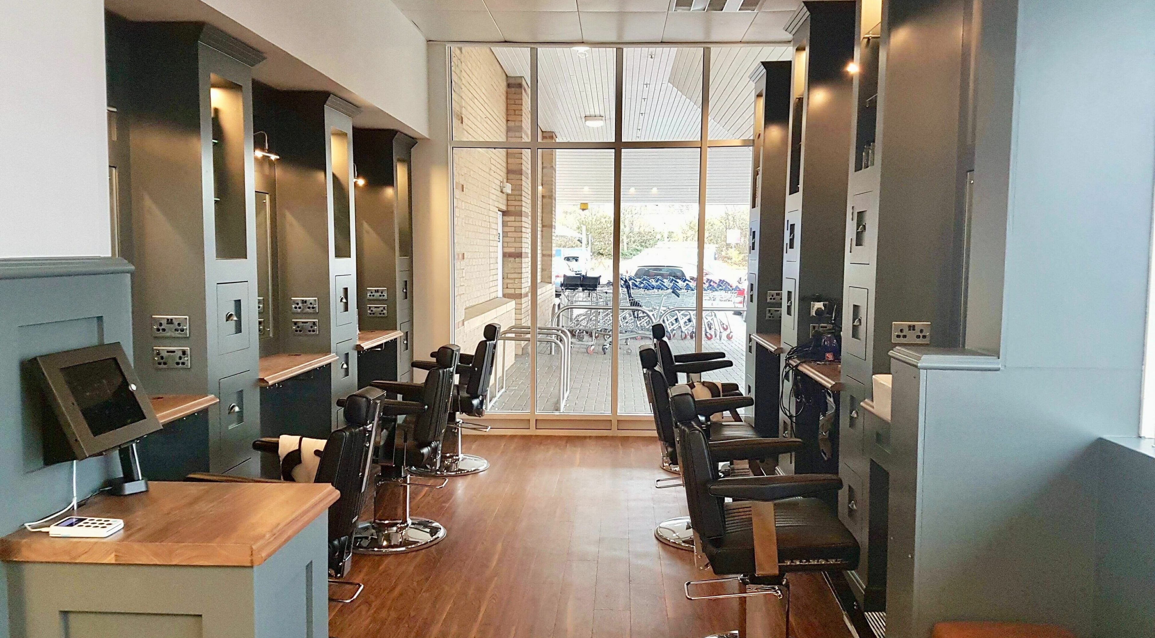 Spacious interior of Gould Barbers Huntingdon, England, GB, showcasing modern barber chairs and sleek decor.