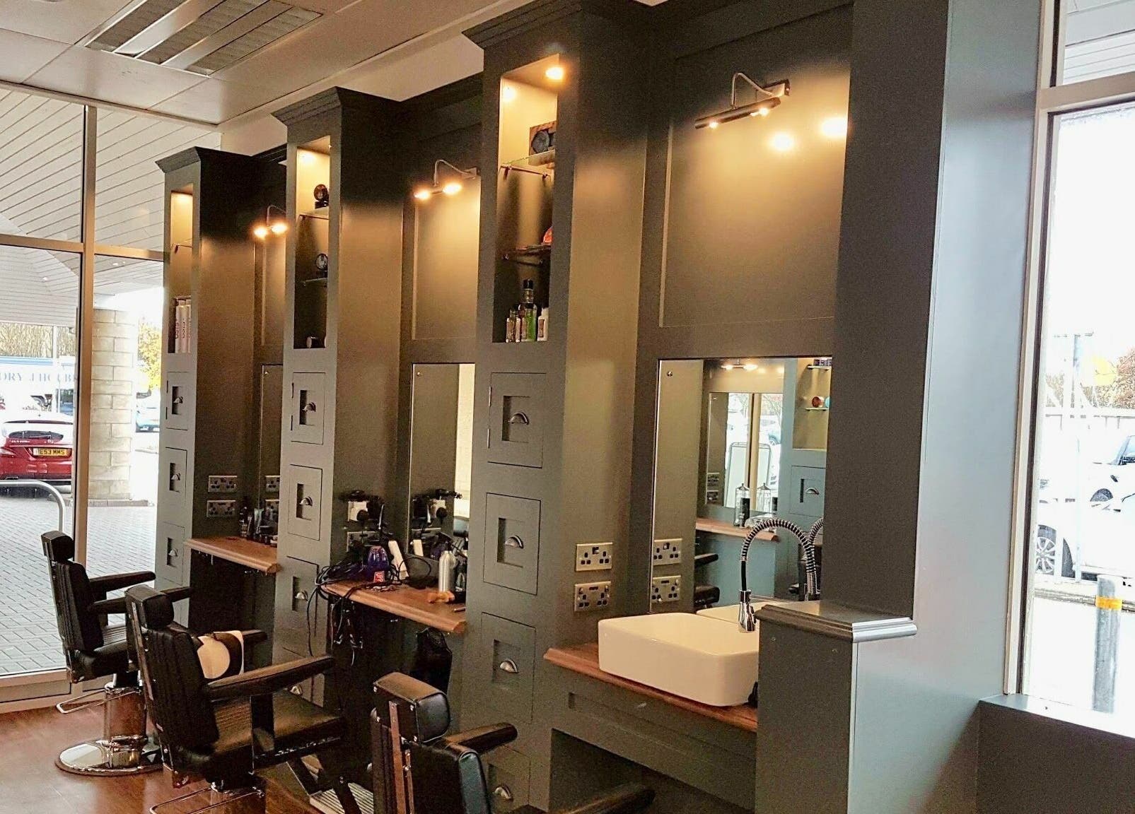 Stylish interior of Gould Barbers Huntingdon with modern chairs, mirrors, and a sink in Huntingdon, England, GB.