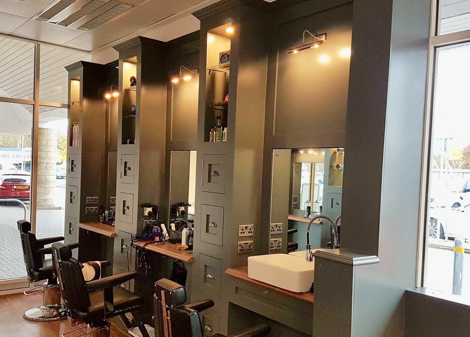 Stylish interior of Gould Barbers Huntingdon with modern chairs, mirrors, and a sink in Huntingdon, England, GB.