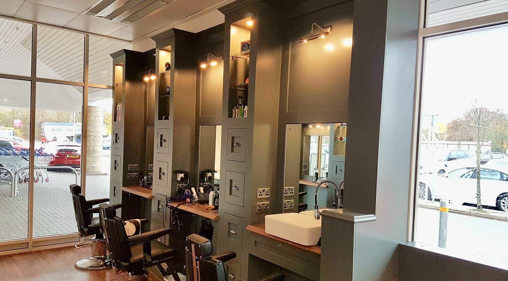 Stylish interior of Gould Barbers Huntingdon with modern chairs, mirrors, and a sink in Huntingdon, England, GB.