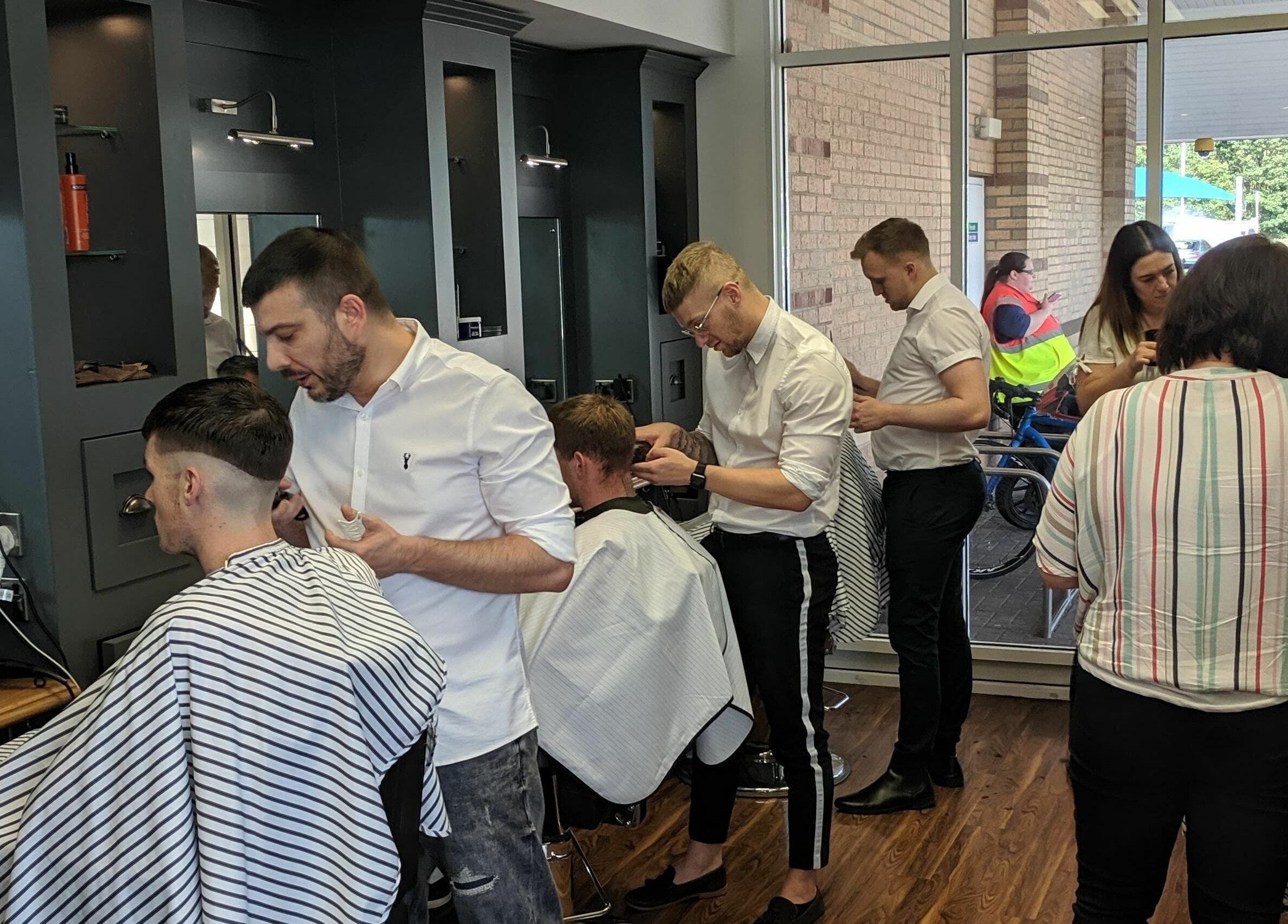 Gould Barbers Huntingdon showcases expert barbers styling clients' hair in modern salon, Huntingdon, England, GB.