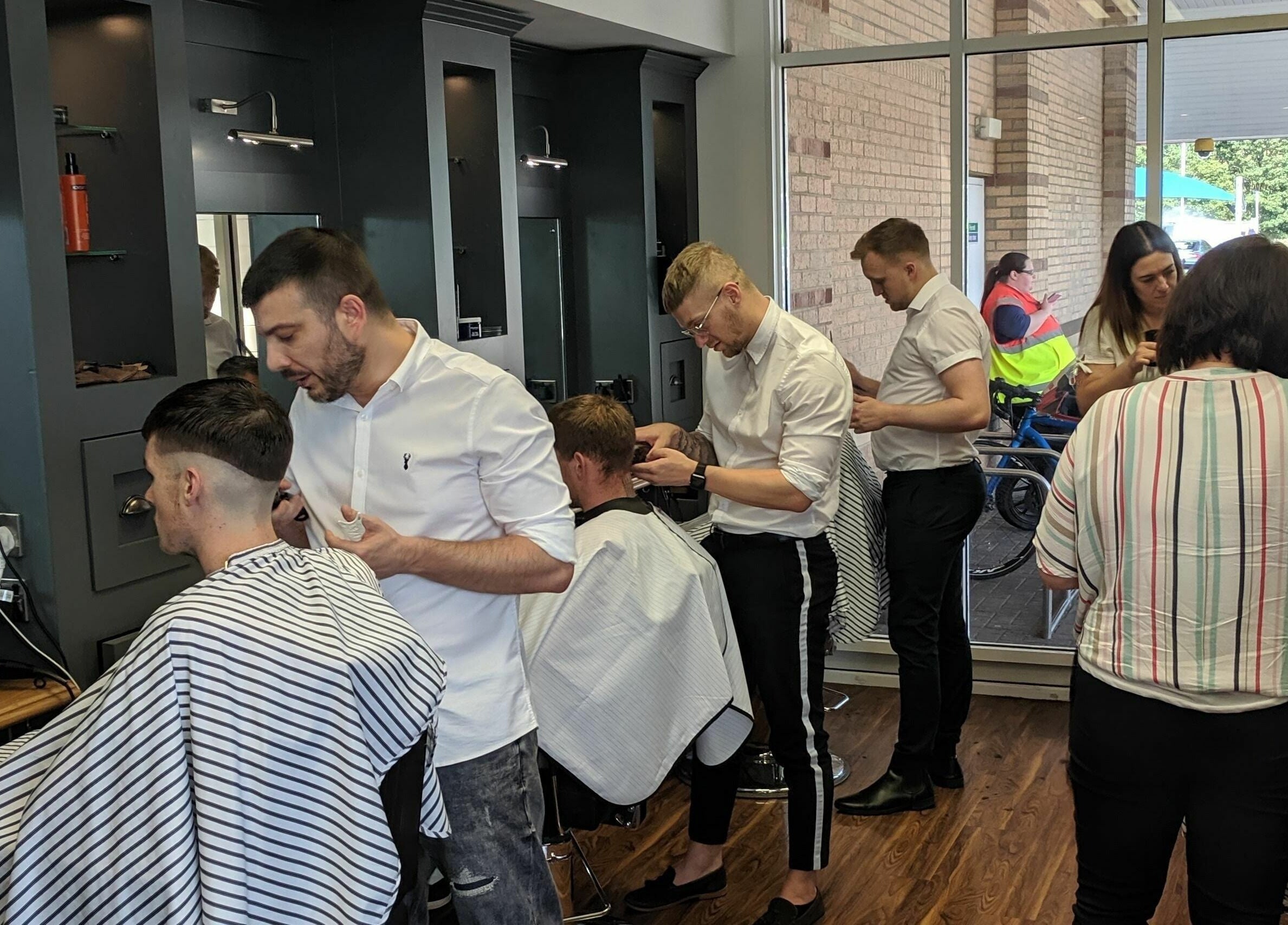 Gould Barbers Huntingdon showcases expert barbers styling clients' hair in modern salon, Huntingdon, England, GB.