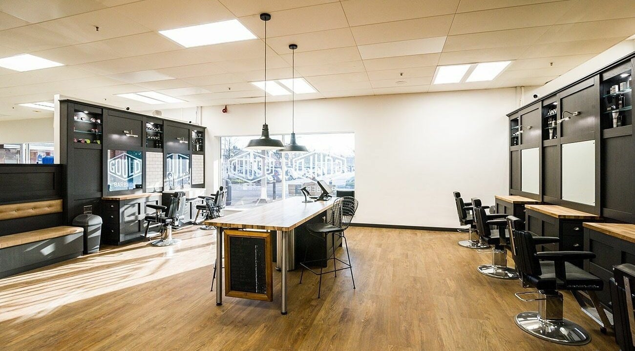 Spacious interior of Gould Barbers Bournemouth, located in Bournemouth, England, GB, with modern chairs and mirrors.