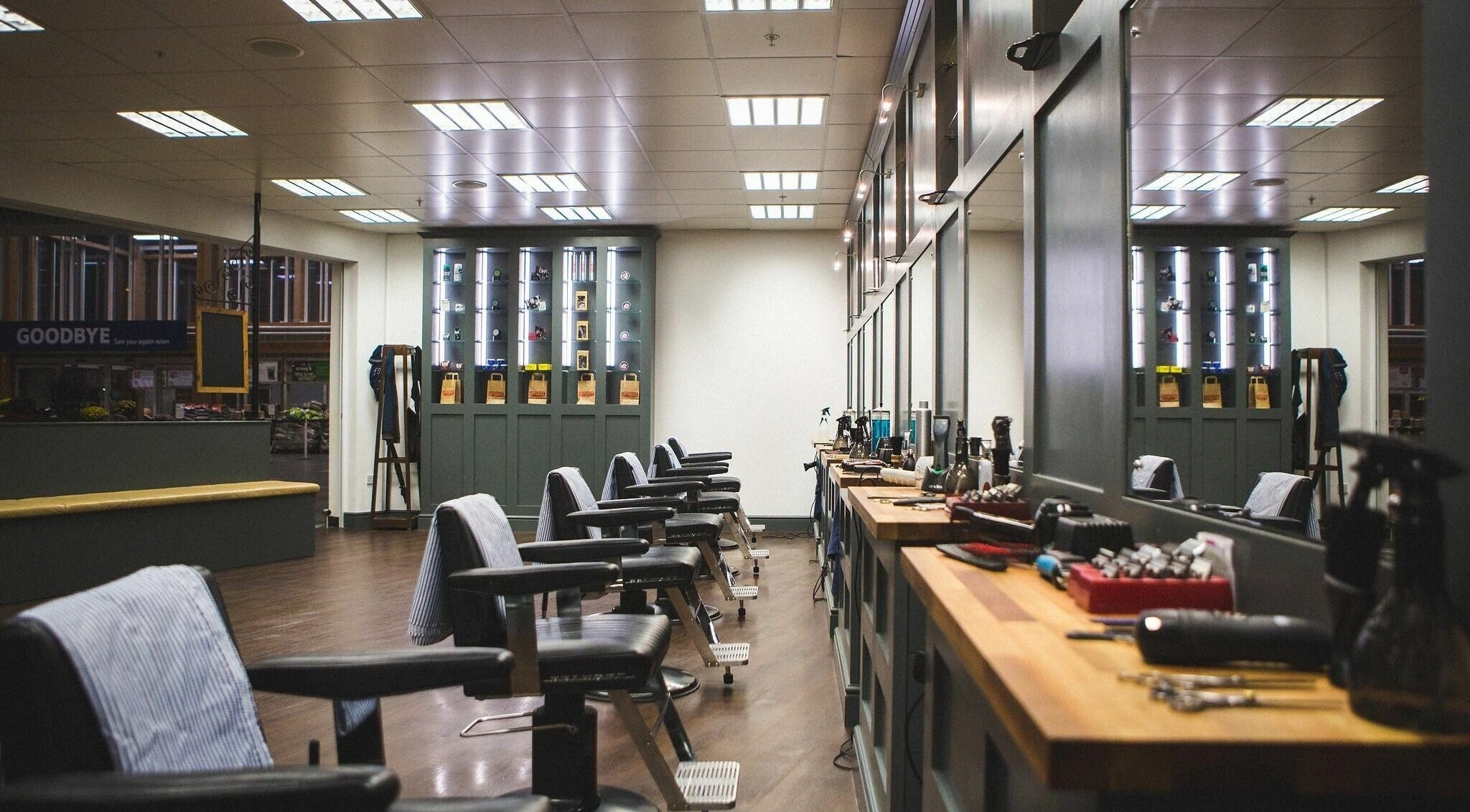 Interior of Gould Barbers Chesterfield, England, GB. Stylish barber chairs with grooming tools on wooden counters.