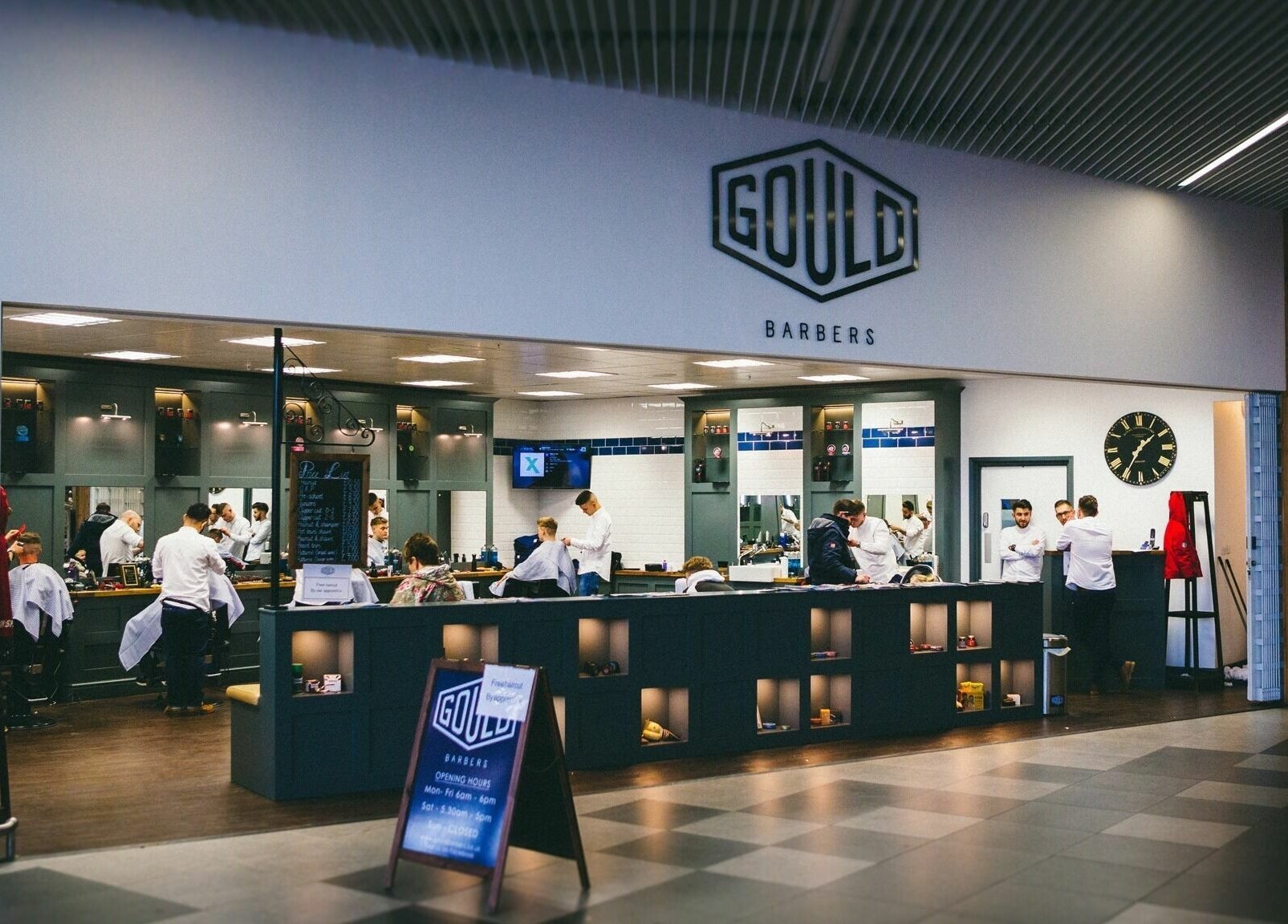 Interior of Gould Barbers Chesterfield, England, GB. Modern setup with barbers at work in a welcoming atmosphere.