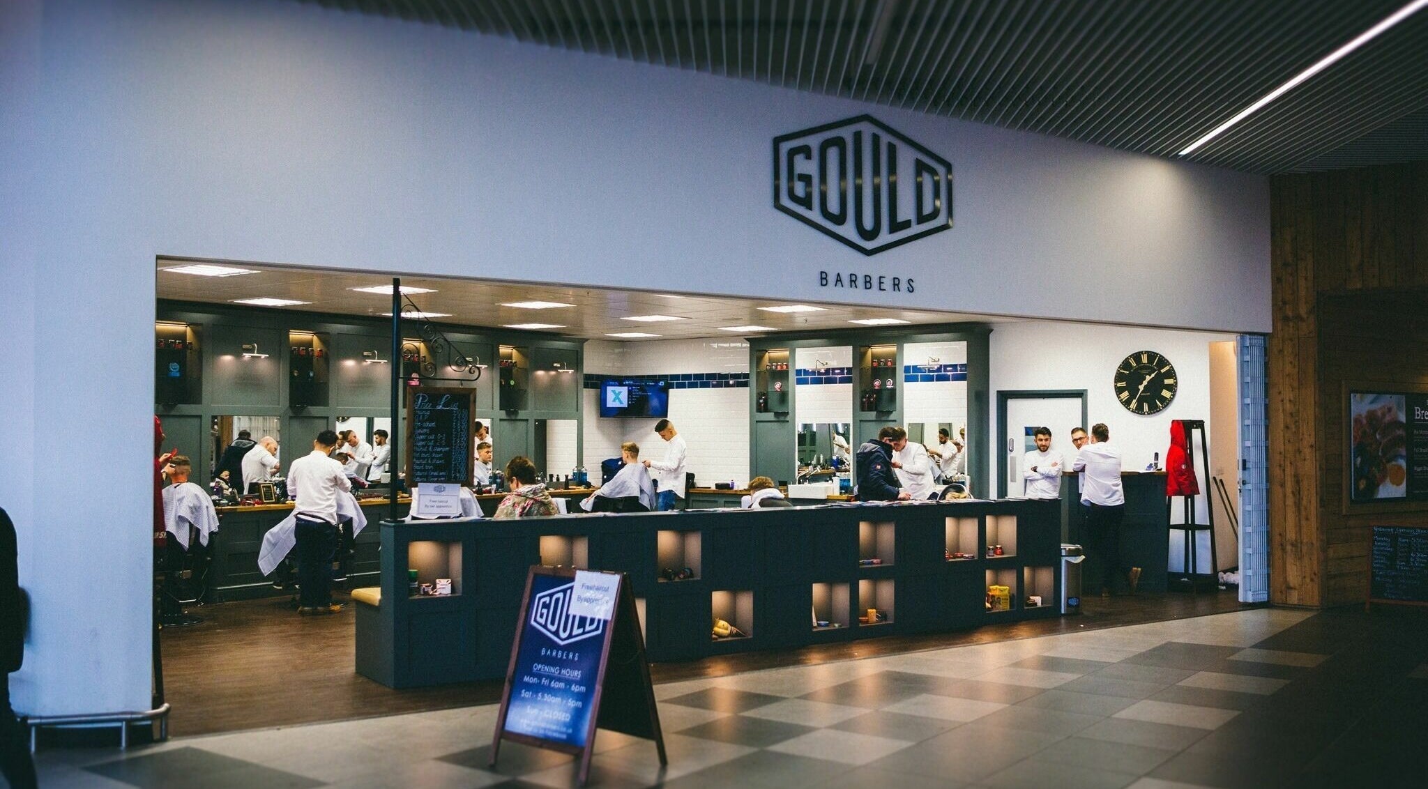 Interior of Gould Barbers Chesterfield, England, GB. Modern setup with barbers at work in a welcoming atmosphere.