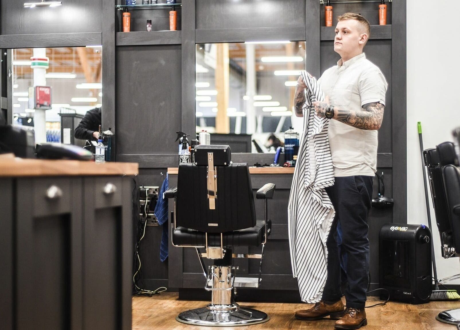 Staff at Gould Barbers Chesterfield preparing chair in Chesterfield, England, GB. Stylish interior with tools.