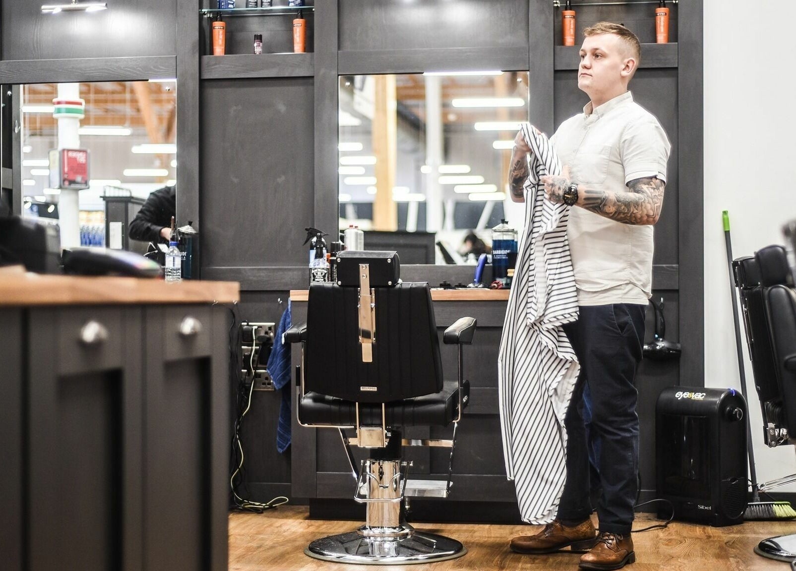 Staff at Gould Barbers Chesterfield preparing chair in Chesterfield, England, GB. Stylish interior with tools.