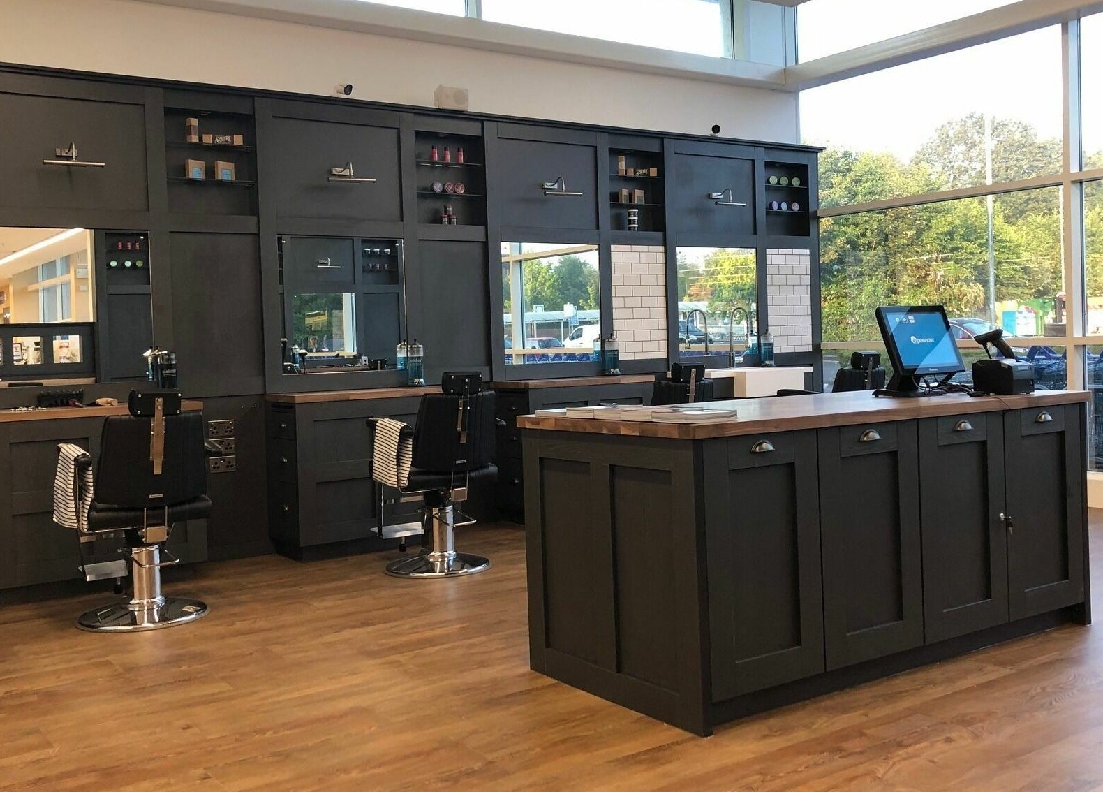 Modern barber shop interior at Gould Barbers Basildon (Pitsea), featuring sleek black chairs. Basildon, England, GB.