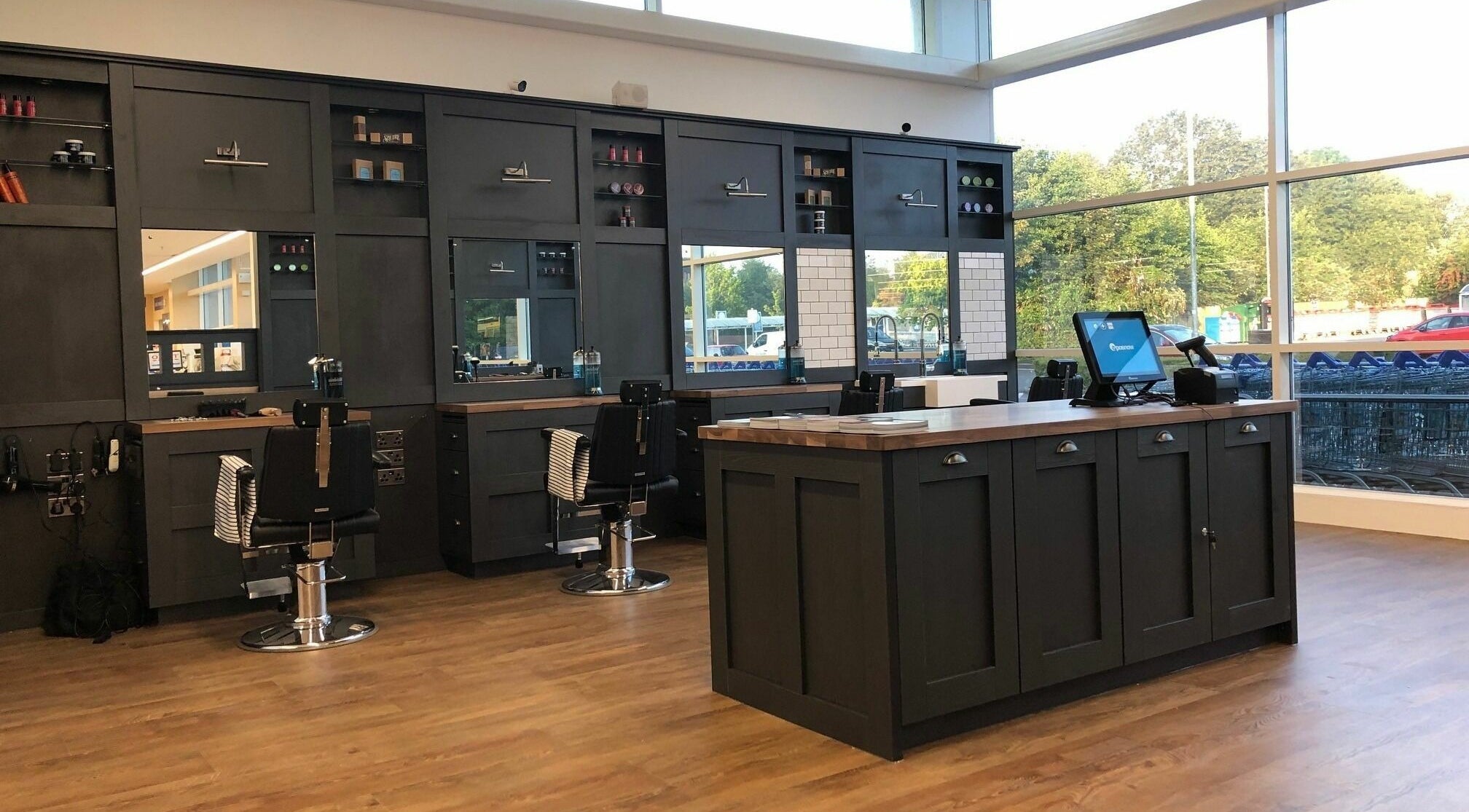 Modern barber shop interior at Gould Barbers Basildon (Pitsea), featuring sleek black chairs. Basildon, England, GB.