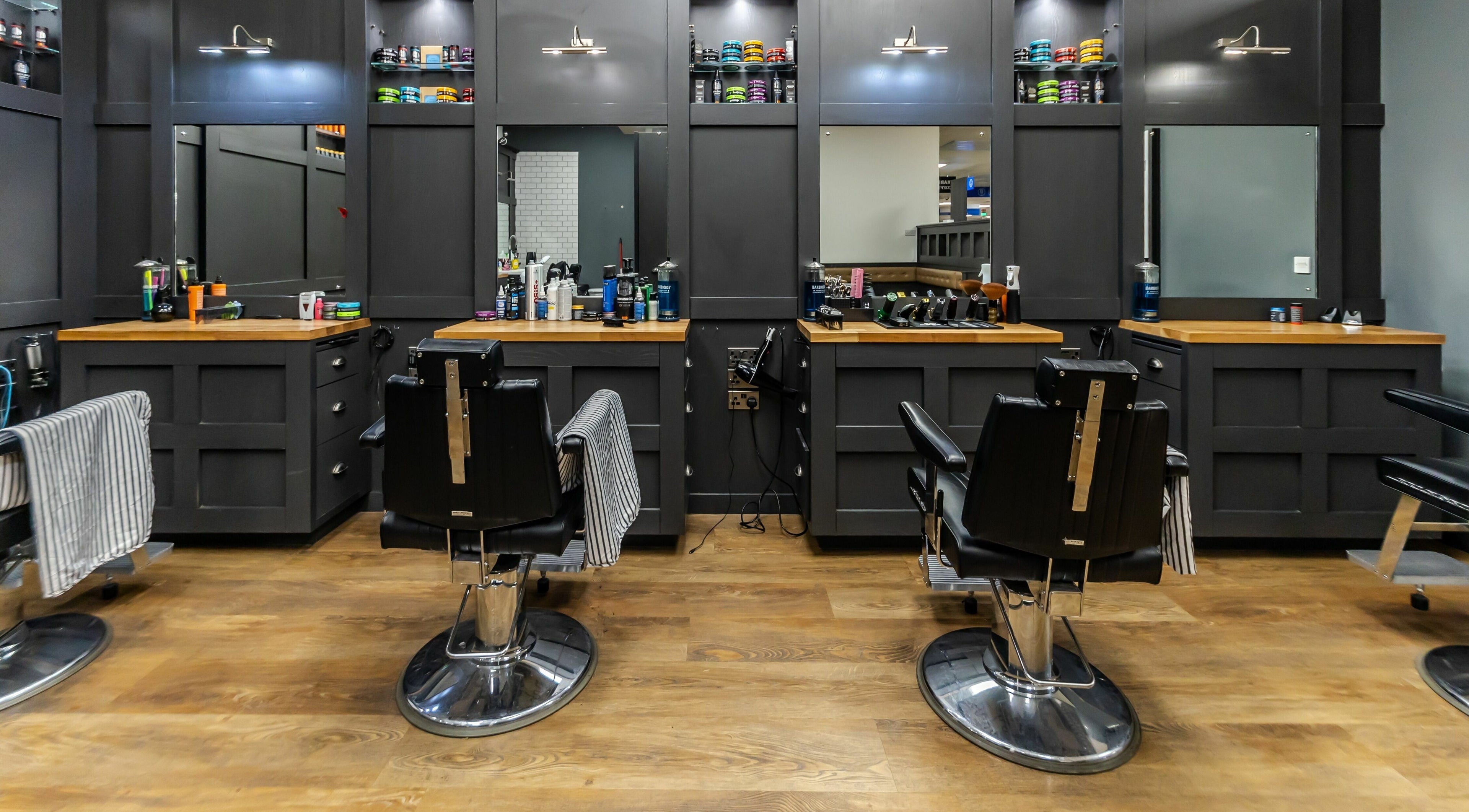Interior of Gould Barbers Sunbury-On-Thames with stylish chairs and grooming products, Sunbury-on-Thames, England, GB.