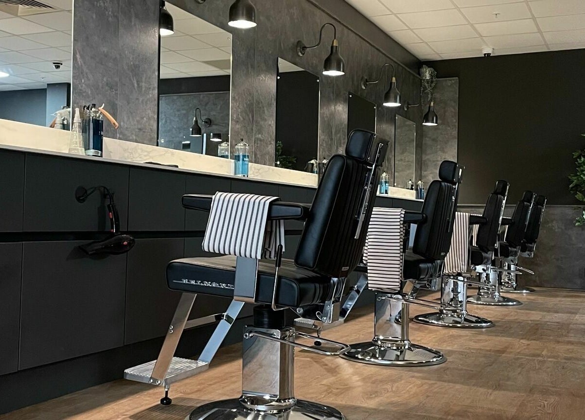 Modern barber chairs at Gould Barbers Cambridge (Bar Hill), sleek interior, Bar Hill, England, GB.