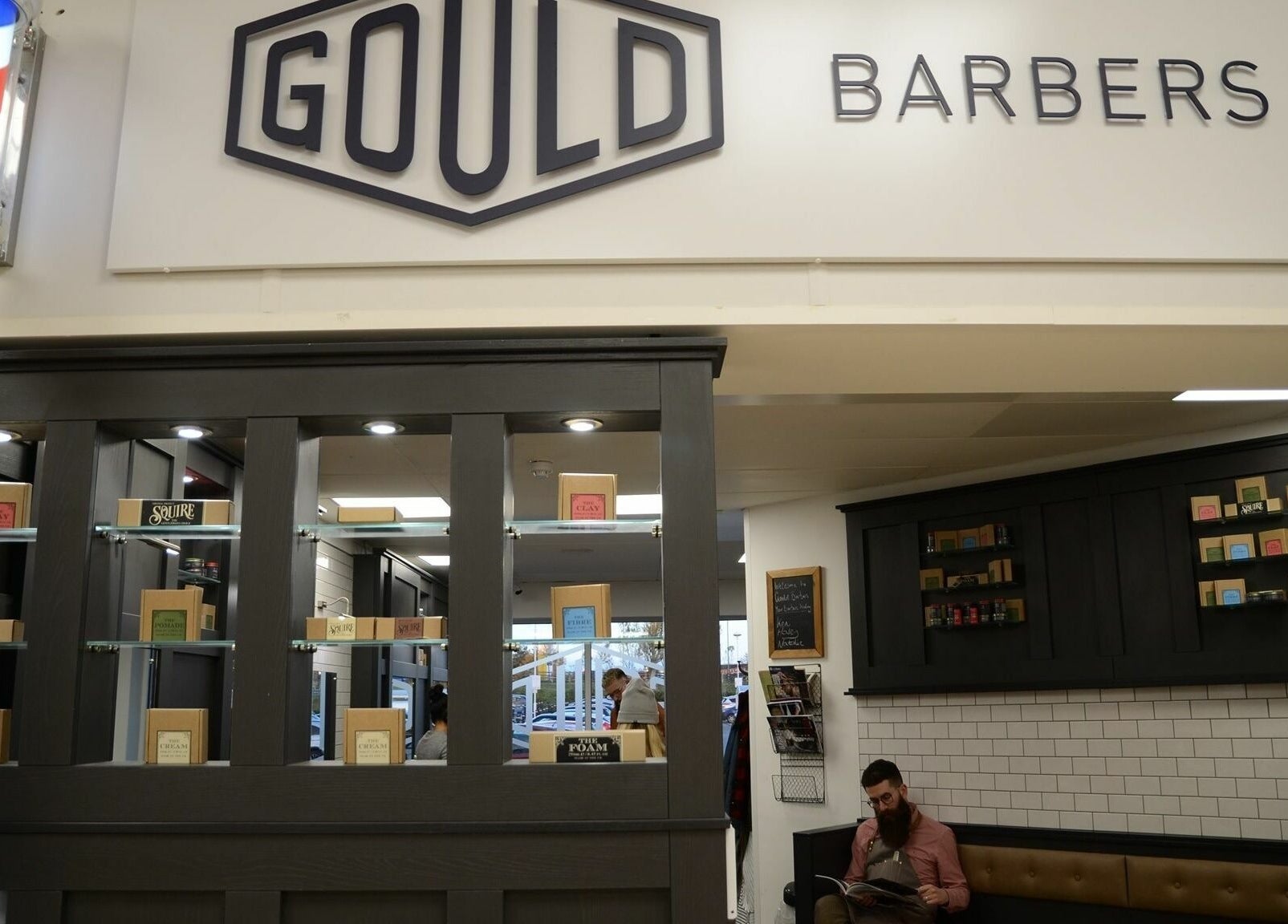 Modern interior of Gould Barbers Cambridge (Bar Hill), showcasing elegant shelving in Bar Hill, England, GB.