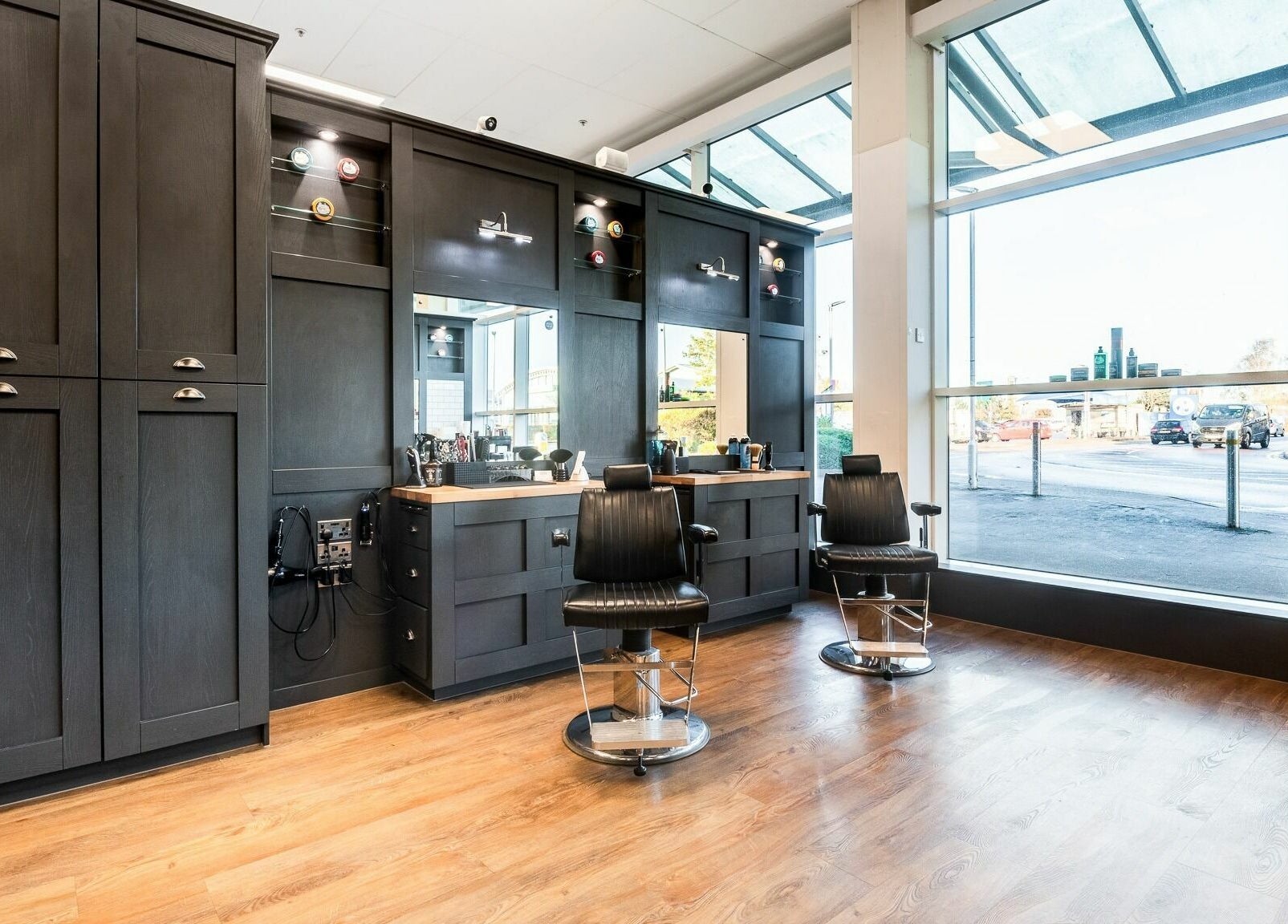 Sleek interior of Gould Barbers Newbury, England, GB with stylish chairs and bright windows.