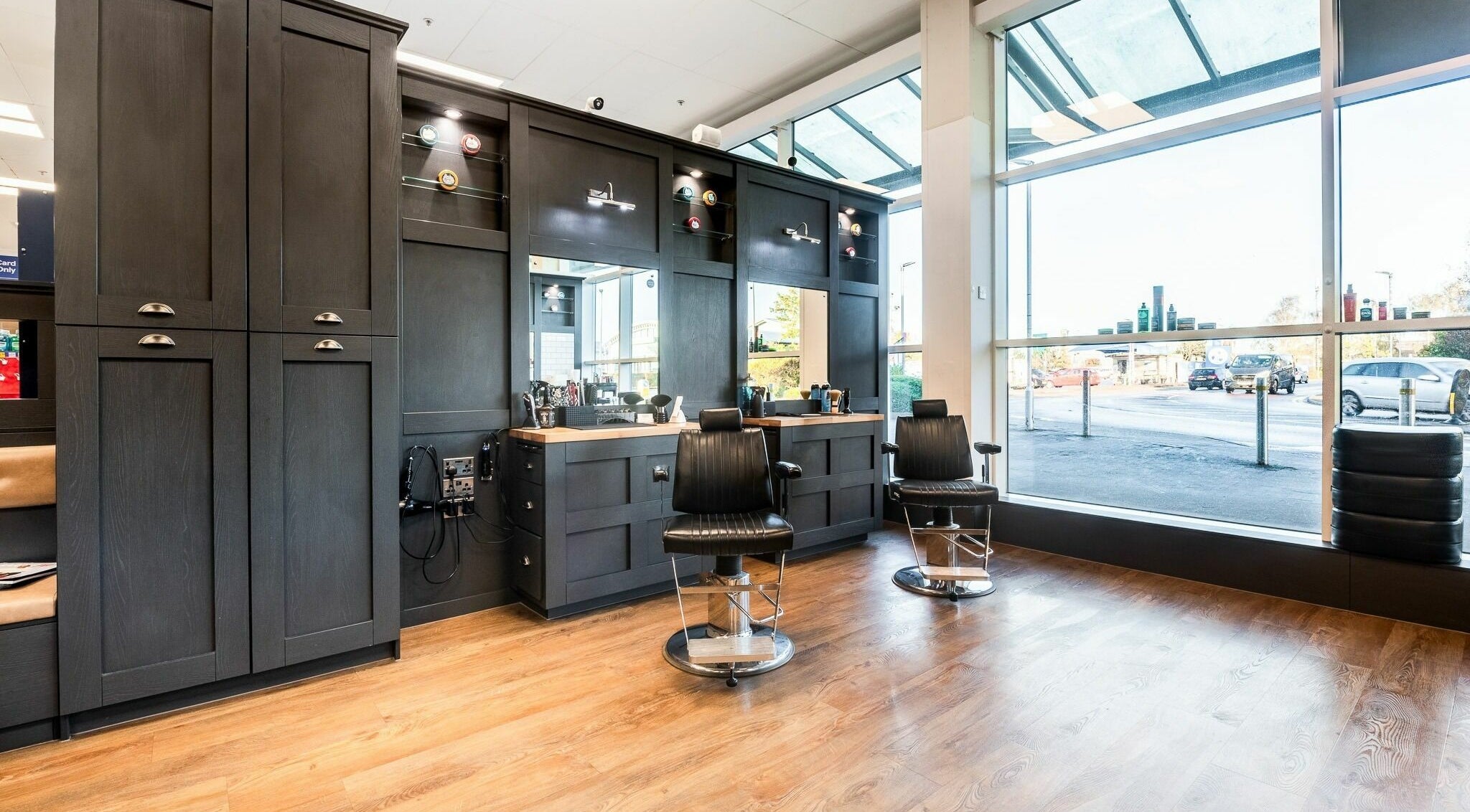 Sleek interior of Gould Barbers Newbury, England, GB with stylish chairs and bright windows.