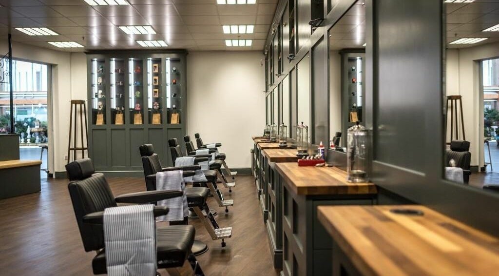 Chic interior of Gould Barbers King's Lynn (Hardwick), King's Lynn, England, GB with reclining chairs and mirrors.