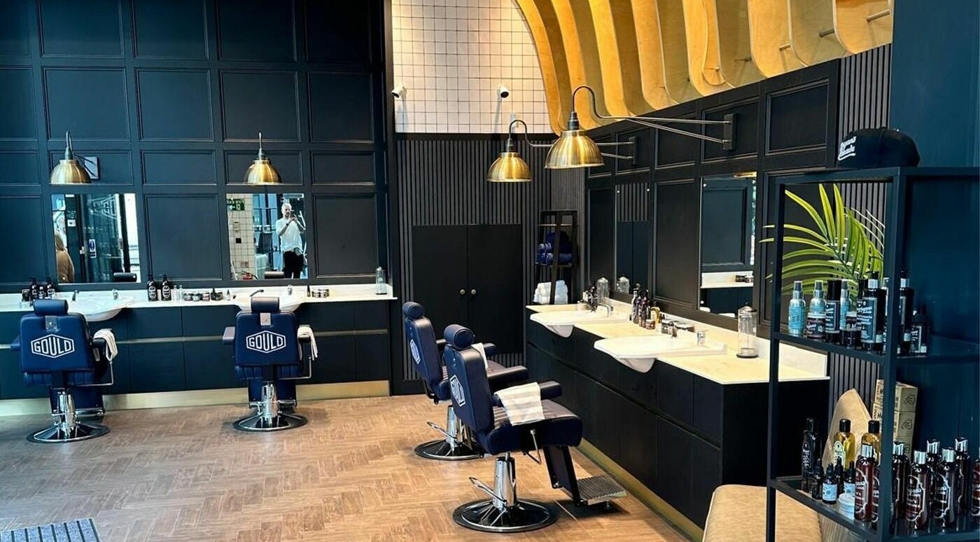 Elegant interior of Gould Barbers Horsham in Horsham, England, GB, featuring modern barber chairs and stylish decor.