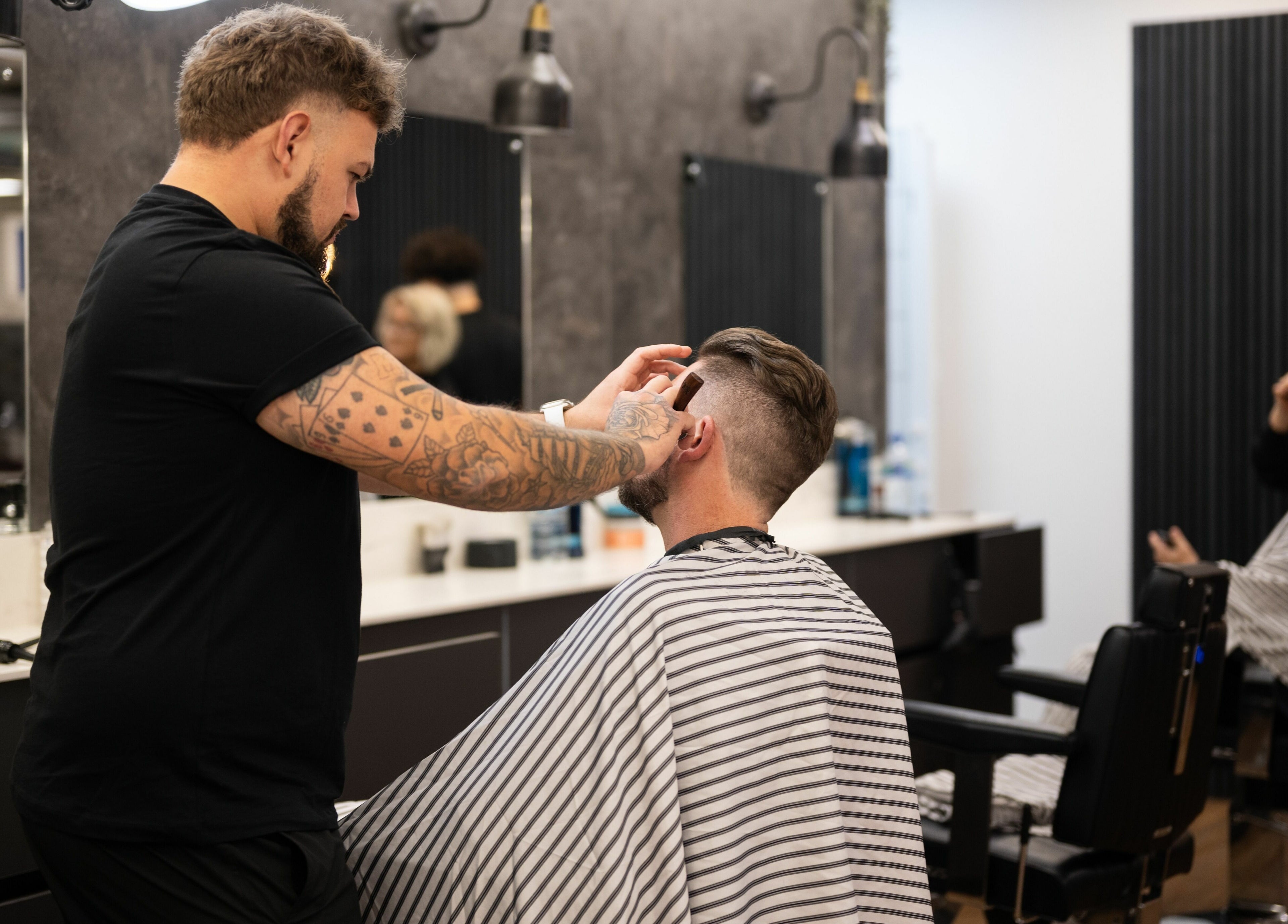 Experienced barber trimming a client's hair at Gould Barbers Horsham, Horsham, England, GB.