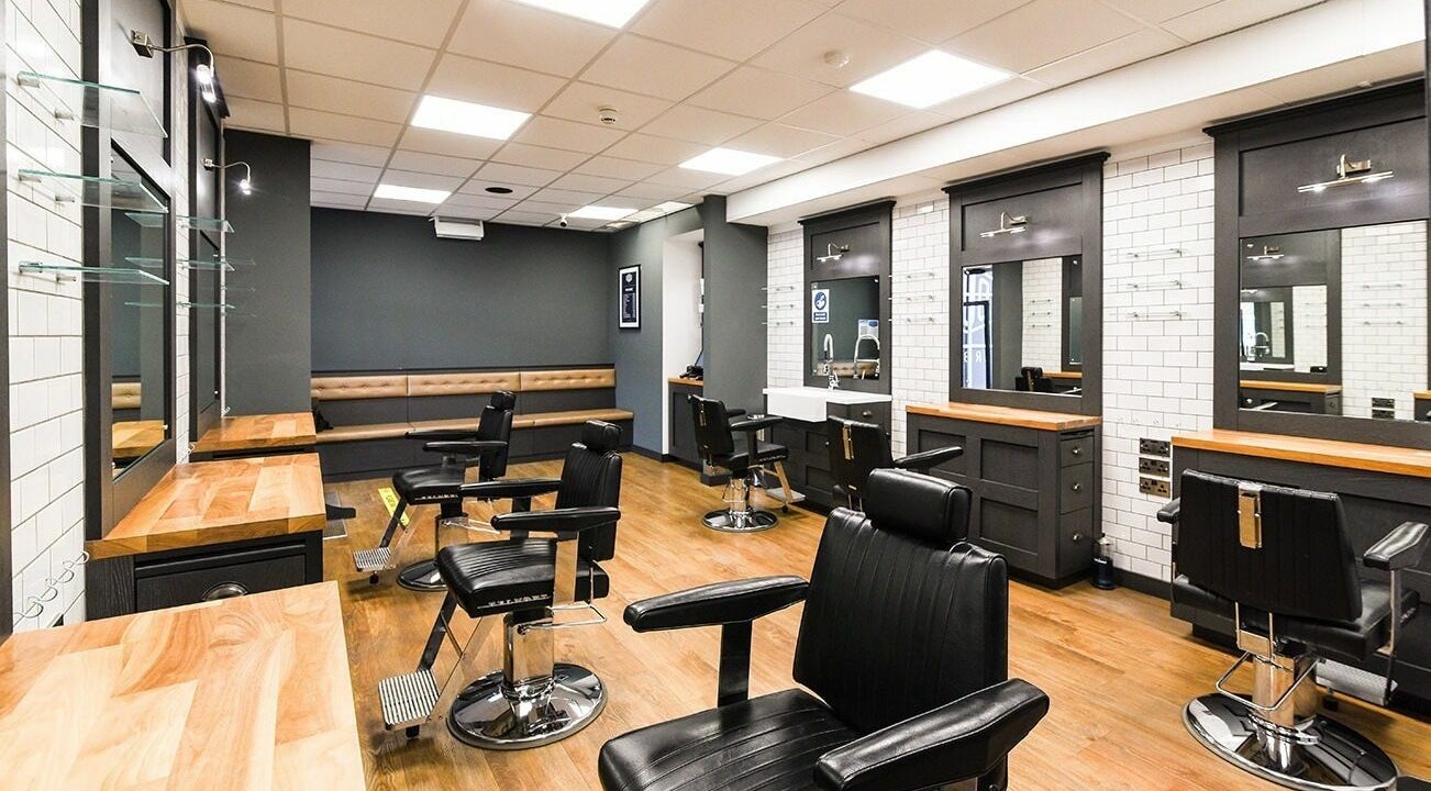 Modern interior of Gould Barbers Stratford-Upon-Avon in Stratford-upon-Avon, England, GB with sleek black chairs.