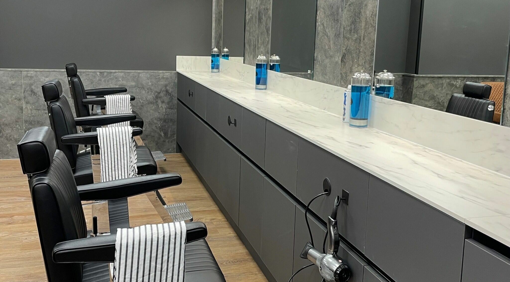 Sleek interior of Gould Barbers Colchester, featuring modern chairs and mirrors in Colchester, England, GB.