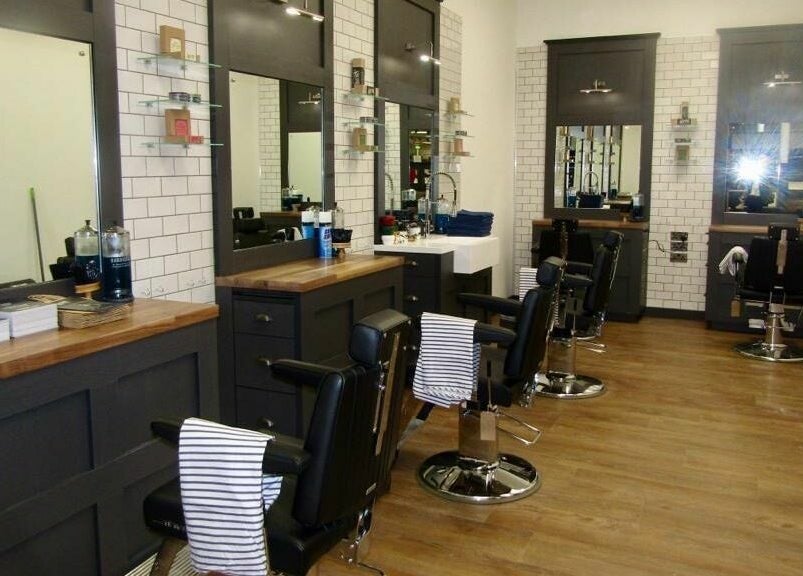 Chic interior of Gould Barbers Hatfield with sleek chairs and mirrors, Hatfield, England, GB.