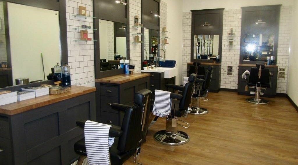 Chic interior of Gould Barbers Hatfield with sleek chairs and mirrors, Hatfield, England, GB.