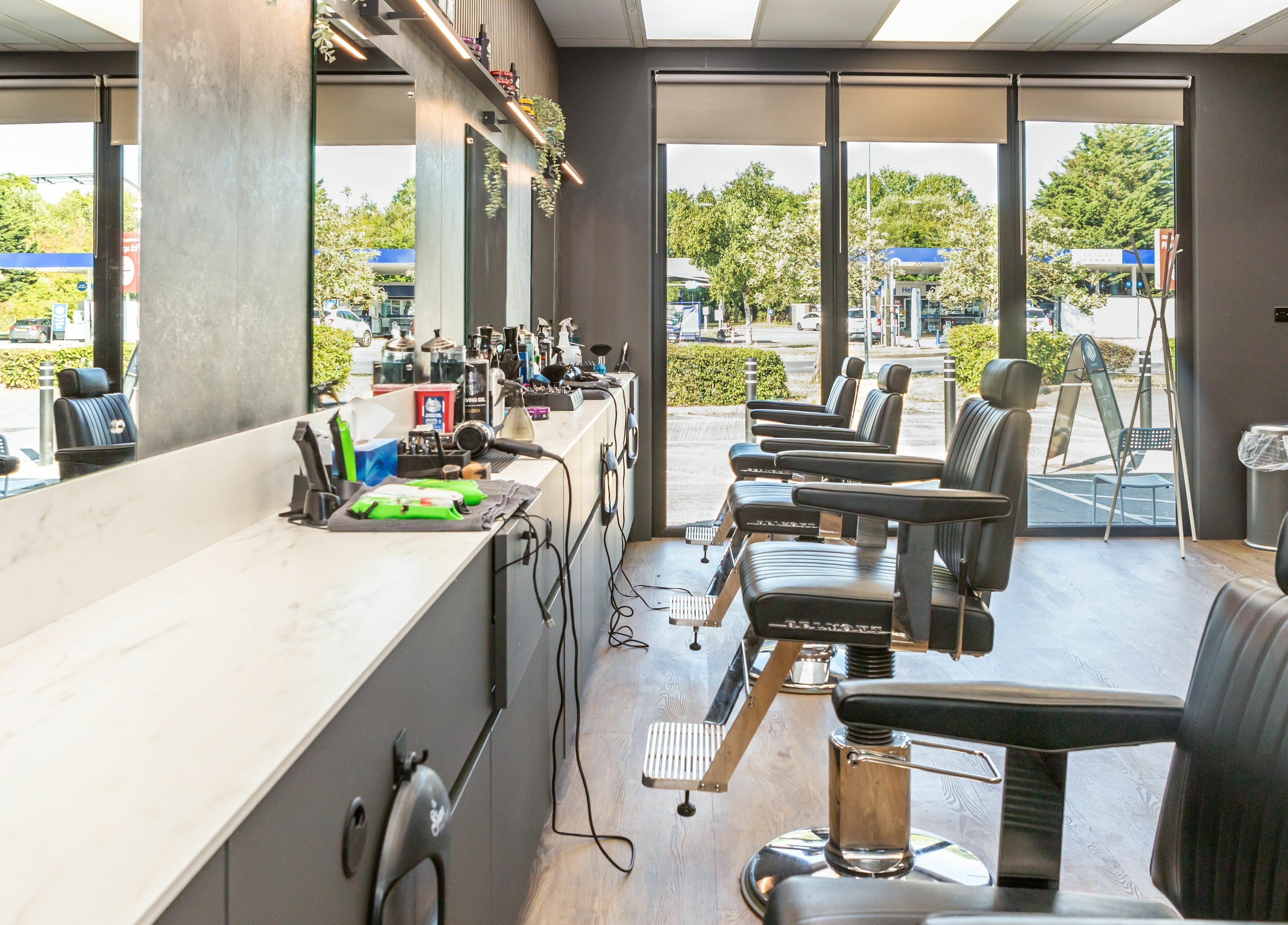 Modern interior of Gould Barbers Lakeside in Lakeside, England, GB, showcasing sleek styling chairs and equipment.