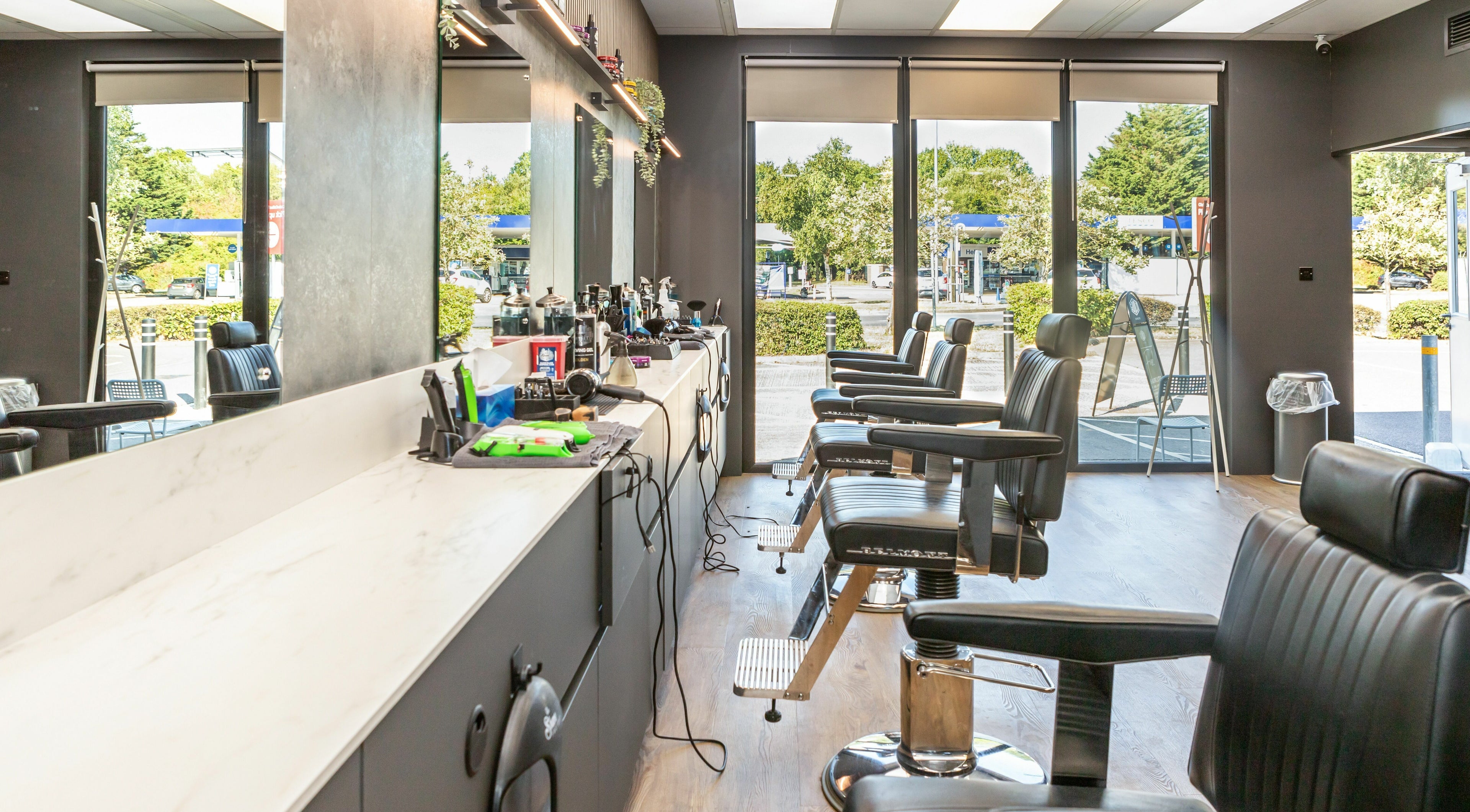 Modern interior of Gould Barbers Lakeside in Lakeside, England, GB, showcasing sleek styling chairs and equipment.