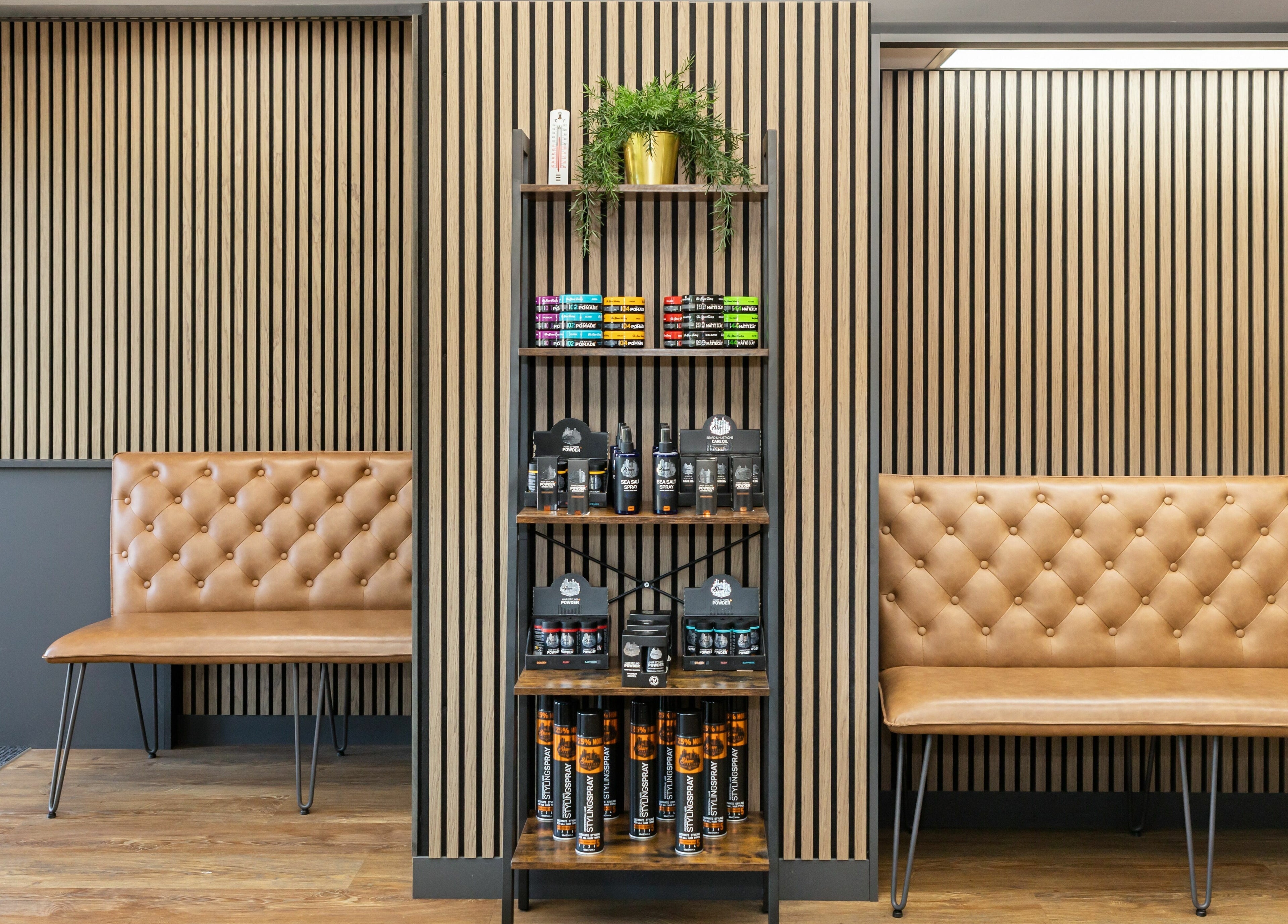 Chic seating and products at Gould Barbers Lakeside, Lakeside, England, GB. Modern wooden decor enhances comfort.