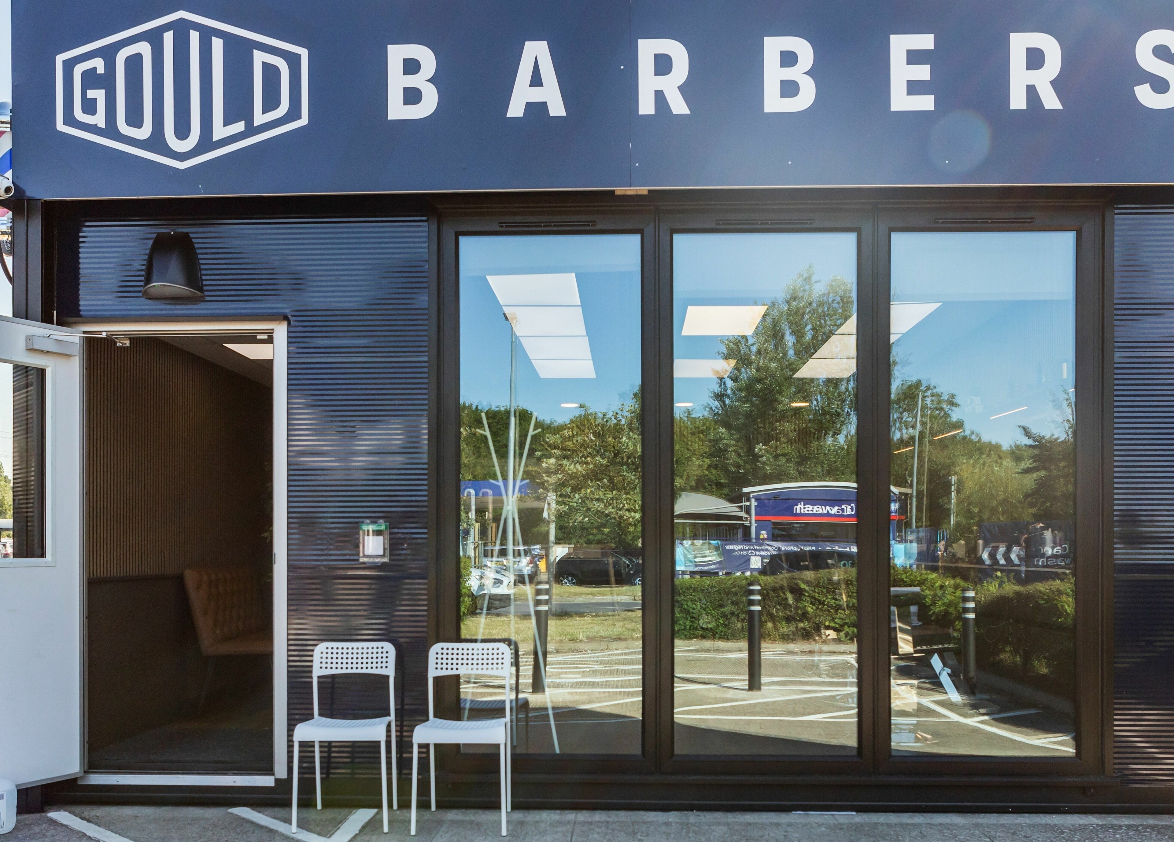 Gould Barbers Lakeside entrance at Lakeside, England, GB, showcasing modern glass doors and inviting seating.