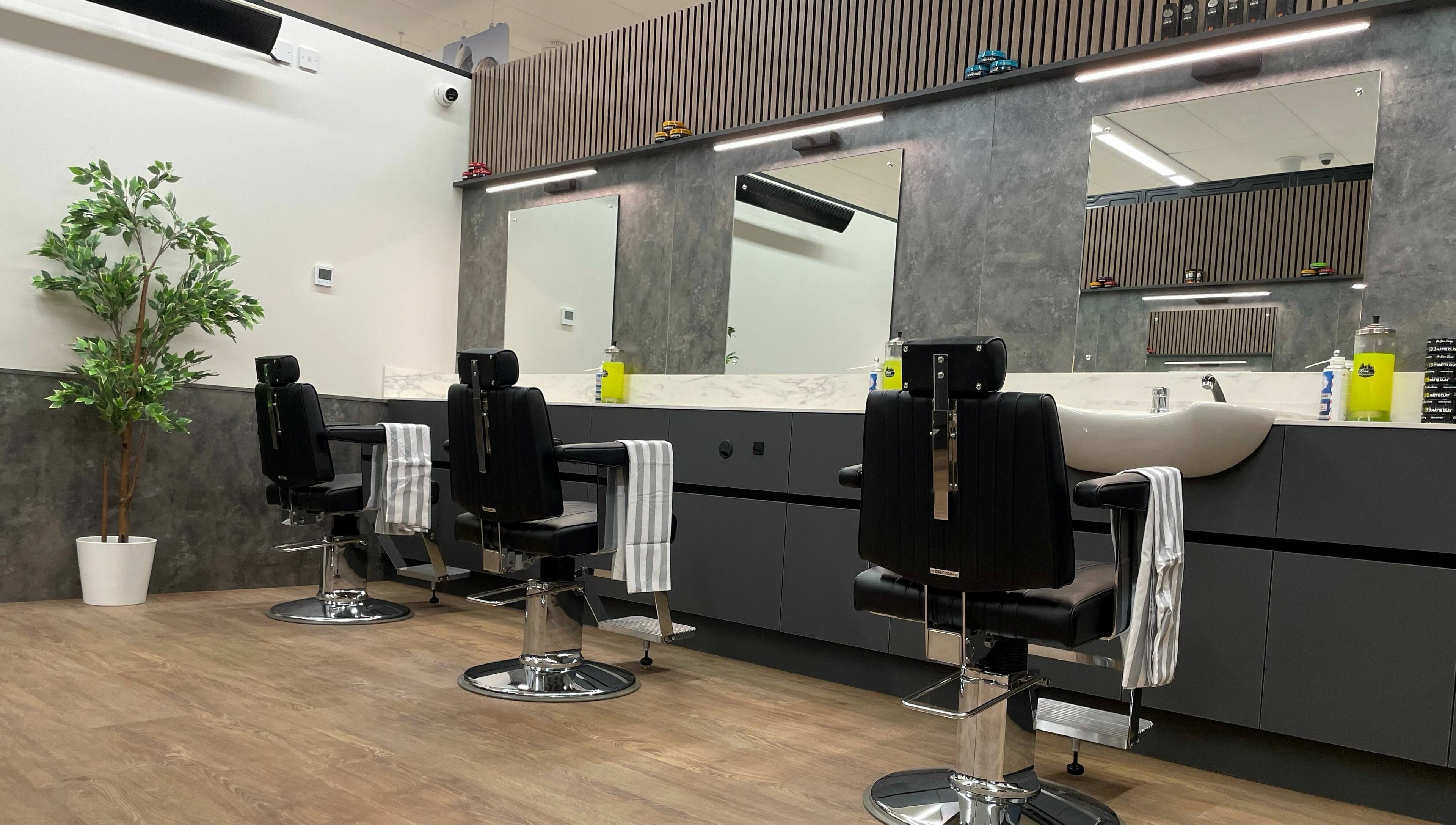 Modern barber chairs at Gould Barbers Sheffield, Sheffield, England, GB with mirrors and stylish decor.