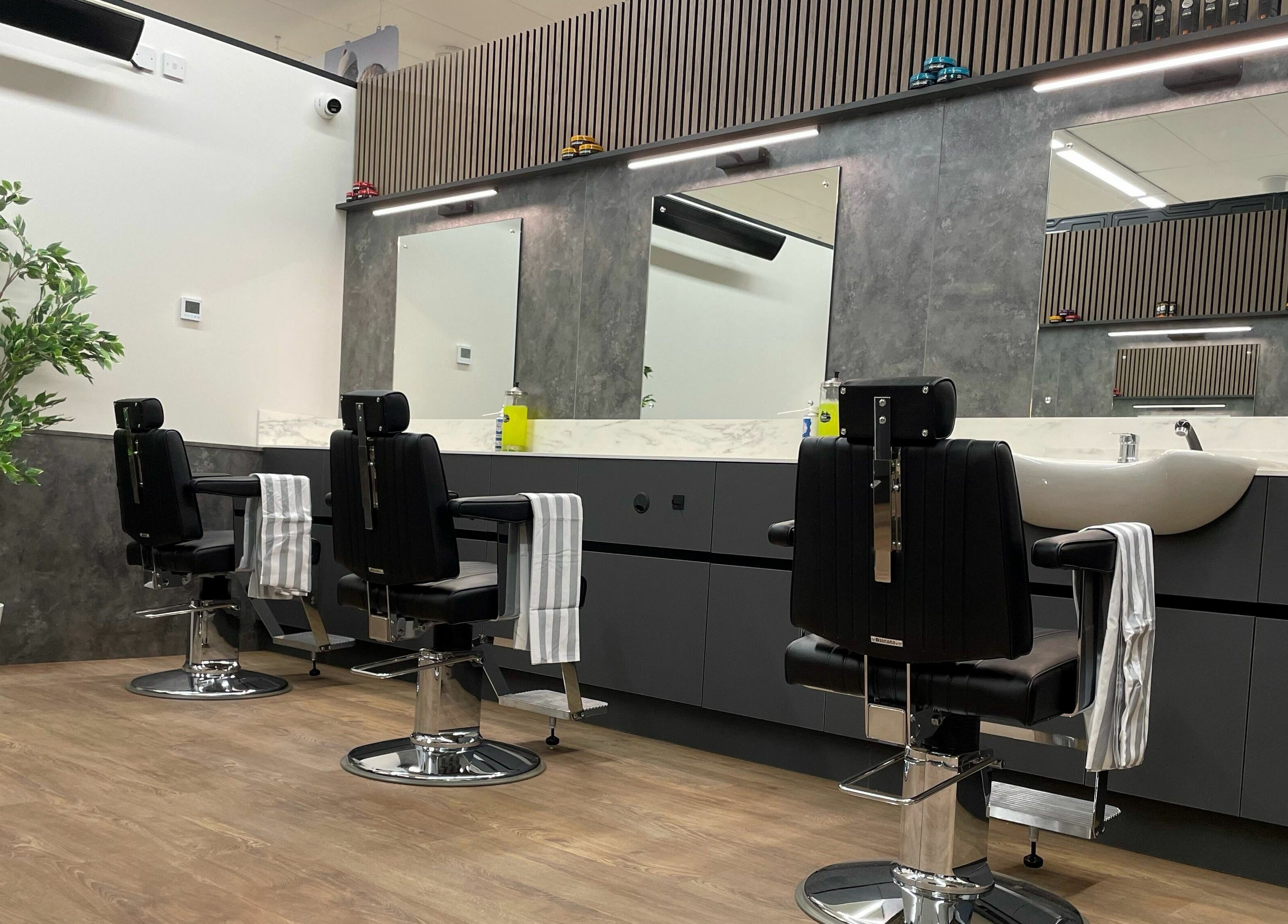 Modern barber chairs at Gould Barbers Sheffield, Sheffield, England, GB with mirrors and stylish decor.
