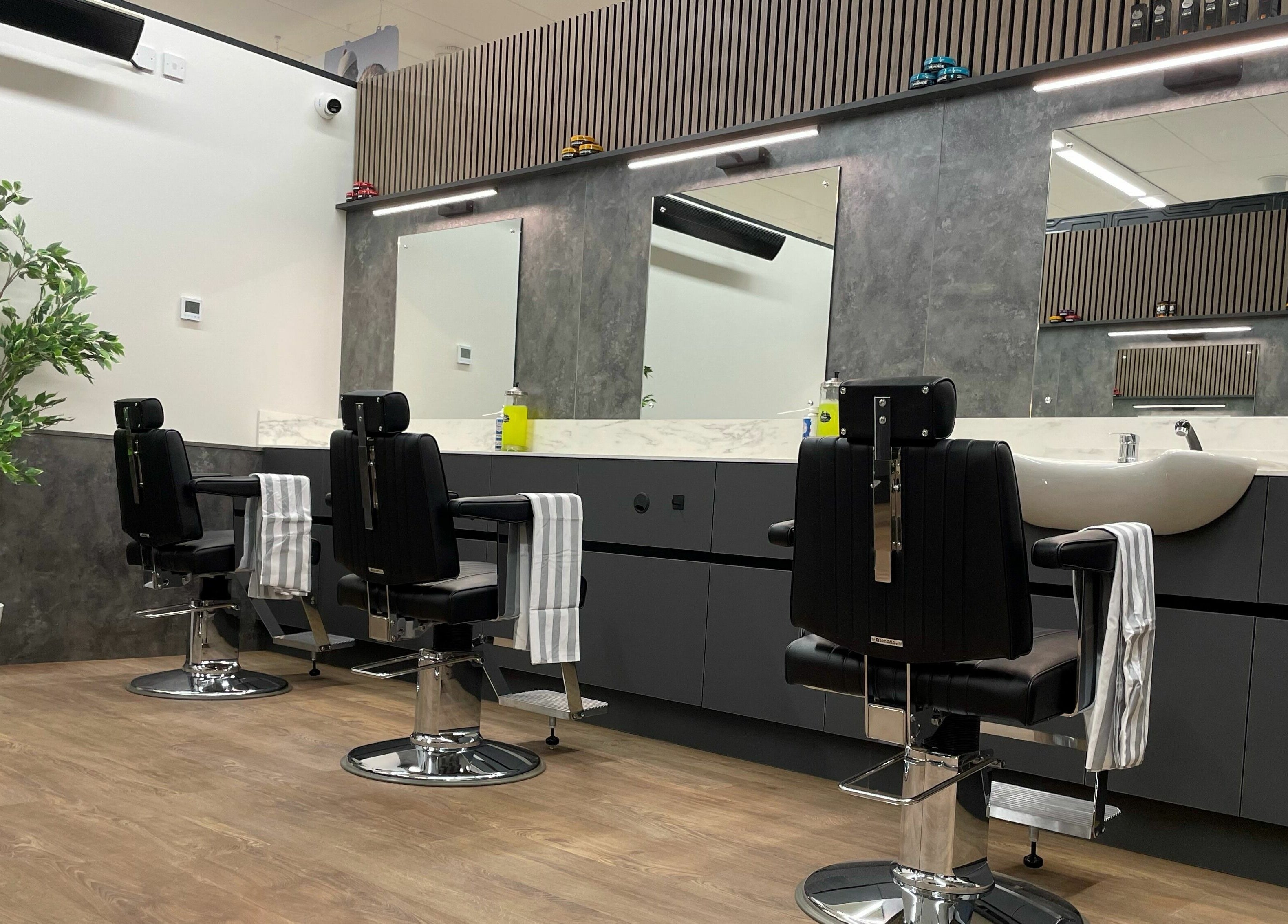 Modern barber chairs at Gould Barbers Sheffield, Sheffield, England, GB with mirrors and stylish decor.