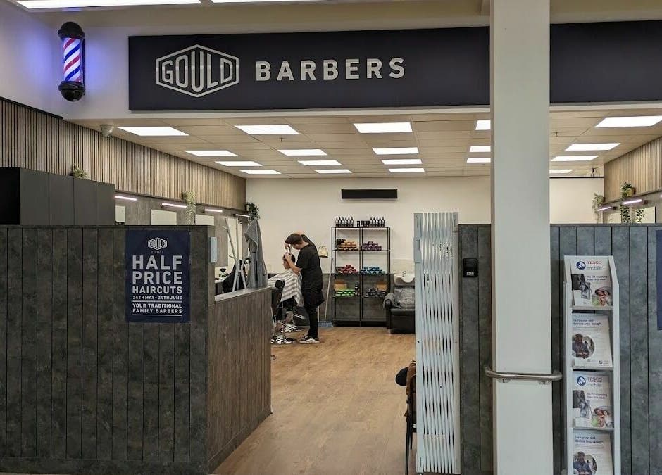 Interior of Gould Barbers Sheffield showcasing modern design and a barber at work. Location: Sheffield, England, GB.