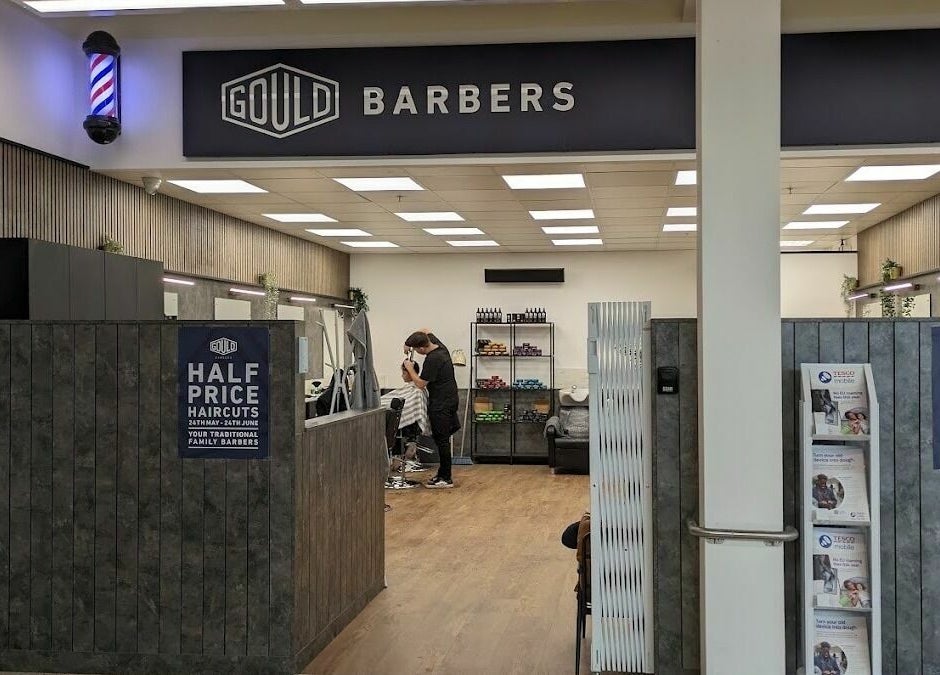 Interior of Gould Barbers Sheffield showcasing modern design and a barber at work. Location: Sheffield, England, GB.