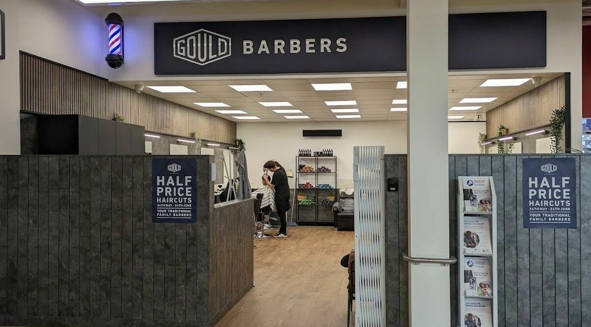 Interior of Gould Barbers Sheffield showcasing modern design and a barber at work. Location: Sheffield, England, GB.