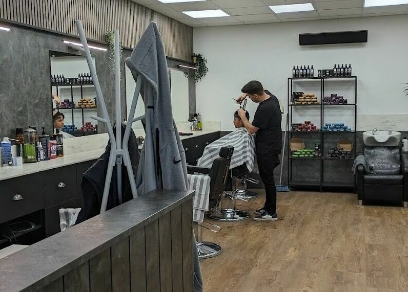 Interior of Gould Barbers Sheffield, Sheffield, England, GB, showcasing a stylist working with a customer.