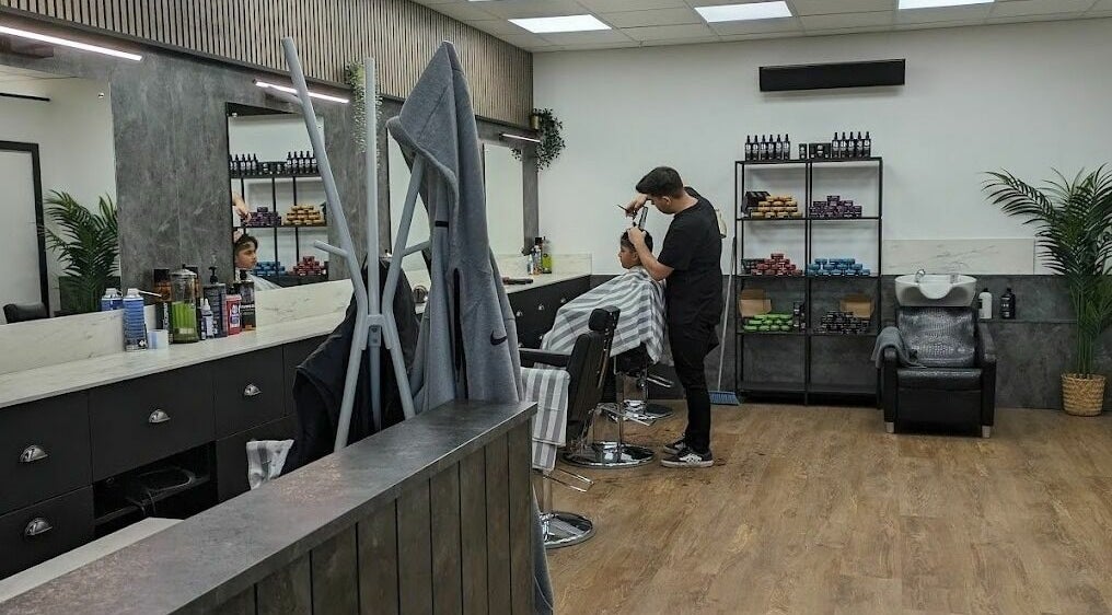 Interior of Gould Barbers Sheffield, Sheffield, England, GB, showcasing a stylist working with a customer.