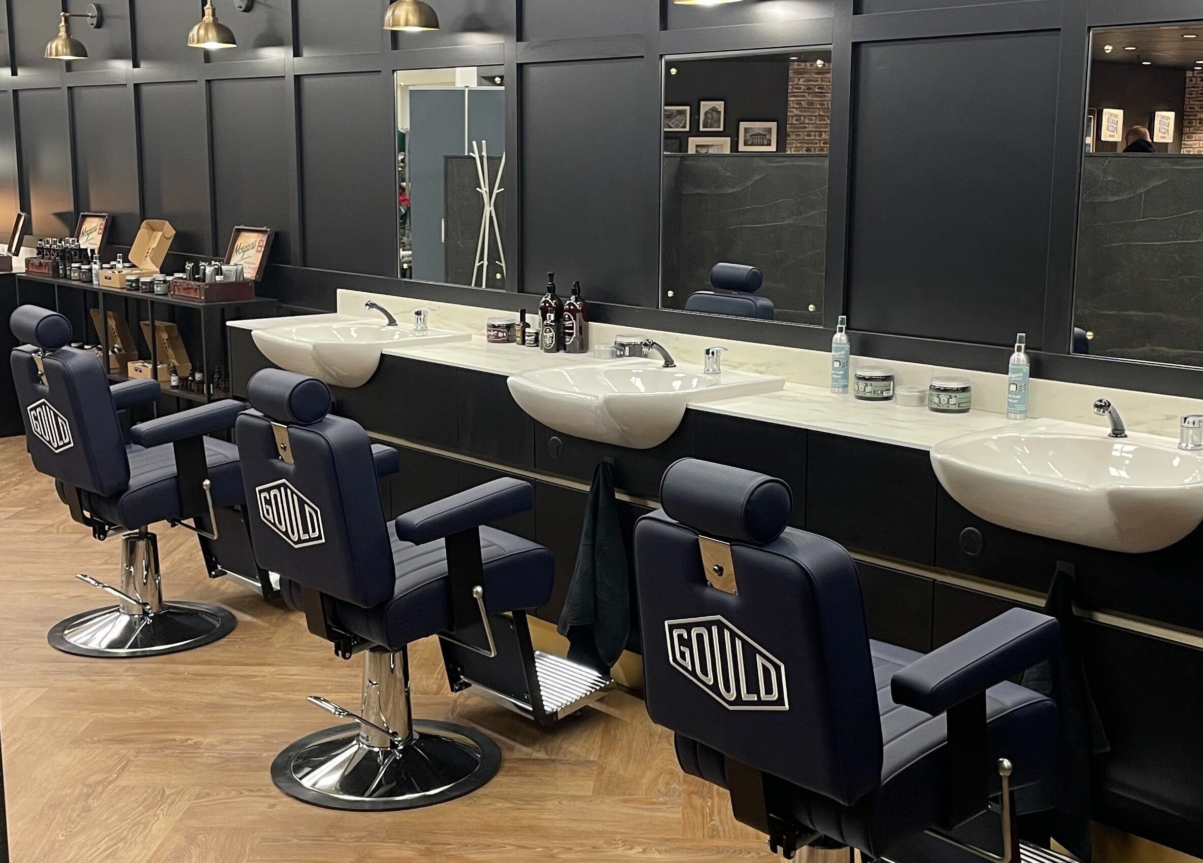 Interior of Gould Barbers Southampton in Bursledon, England, GB with stylish barber chairs and elegant sinks.