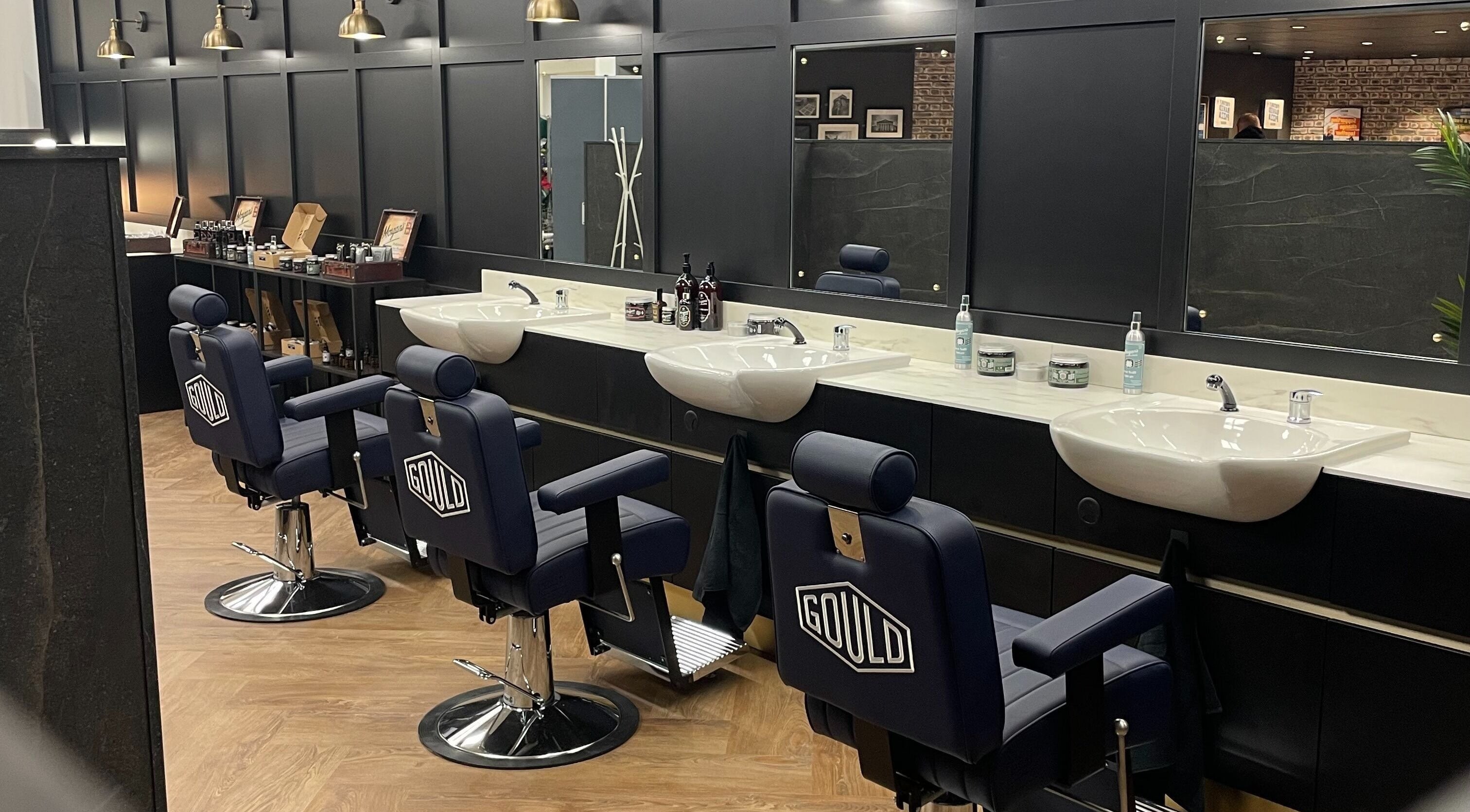 Interior of Gould Barbers Southampton in Bursledon, England, GB with stylish barber chairs and elegant sinks.