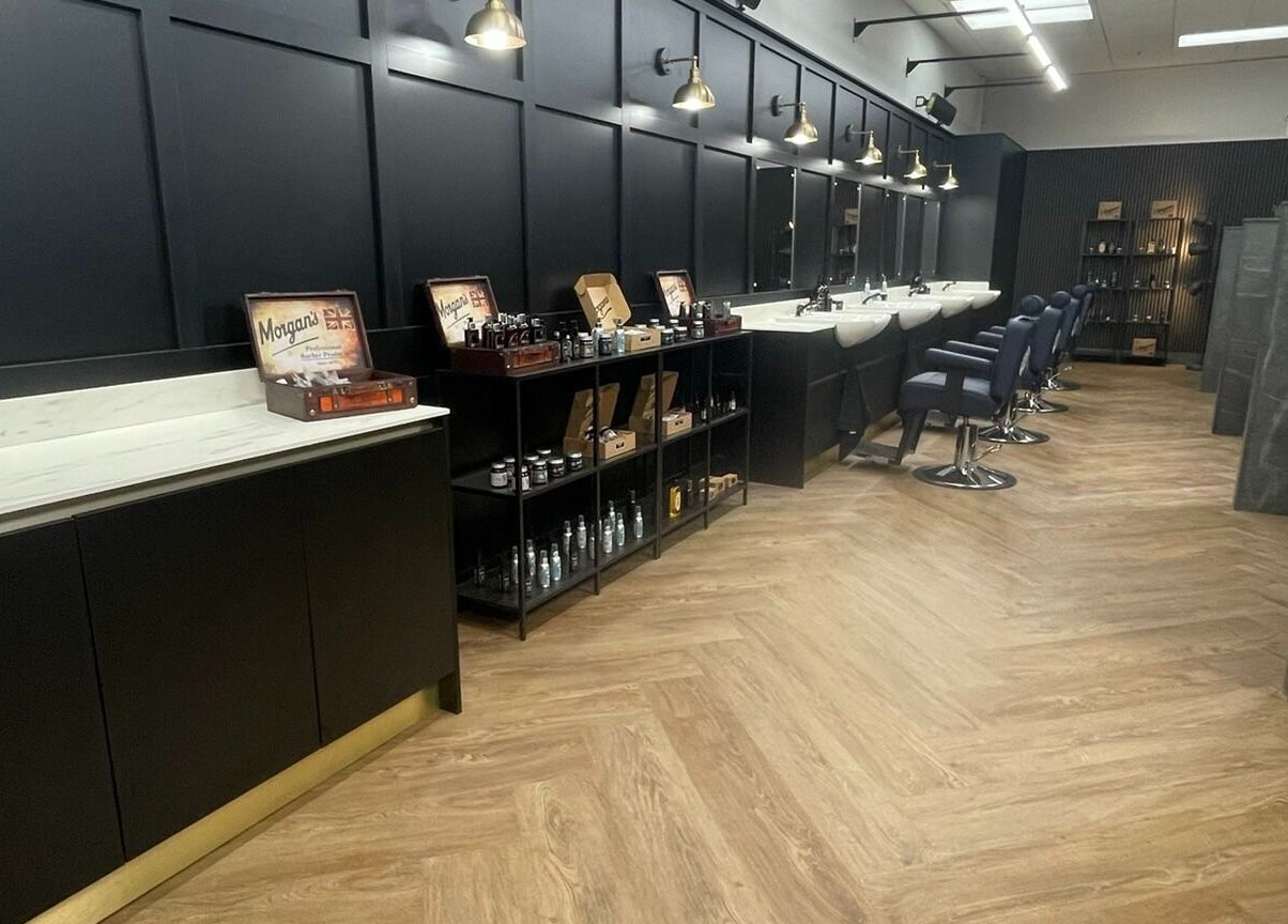 Sleek interior of Gould Barbers Southampton in Bursledon, England, GB with styling chairs and grooming products.