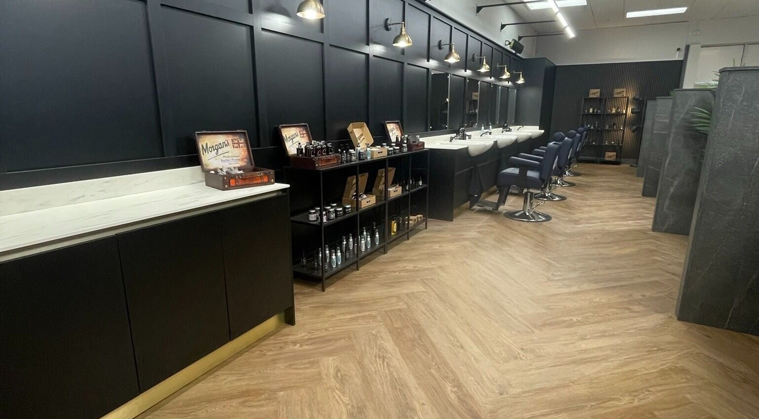 Sleek interior of Gould Barbers Southampton in Bursledon, England, GB with styling chairs and grooming products.
